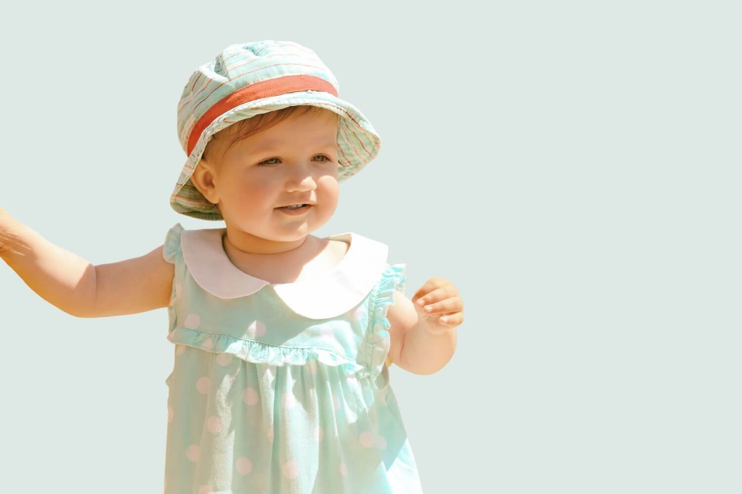 little girl wearing sun hat and polka dot dress