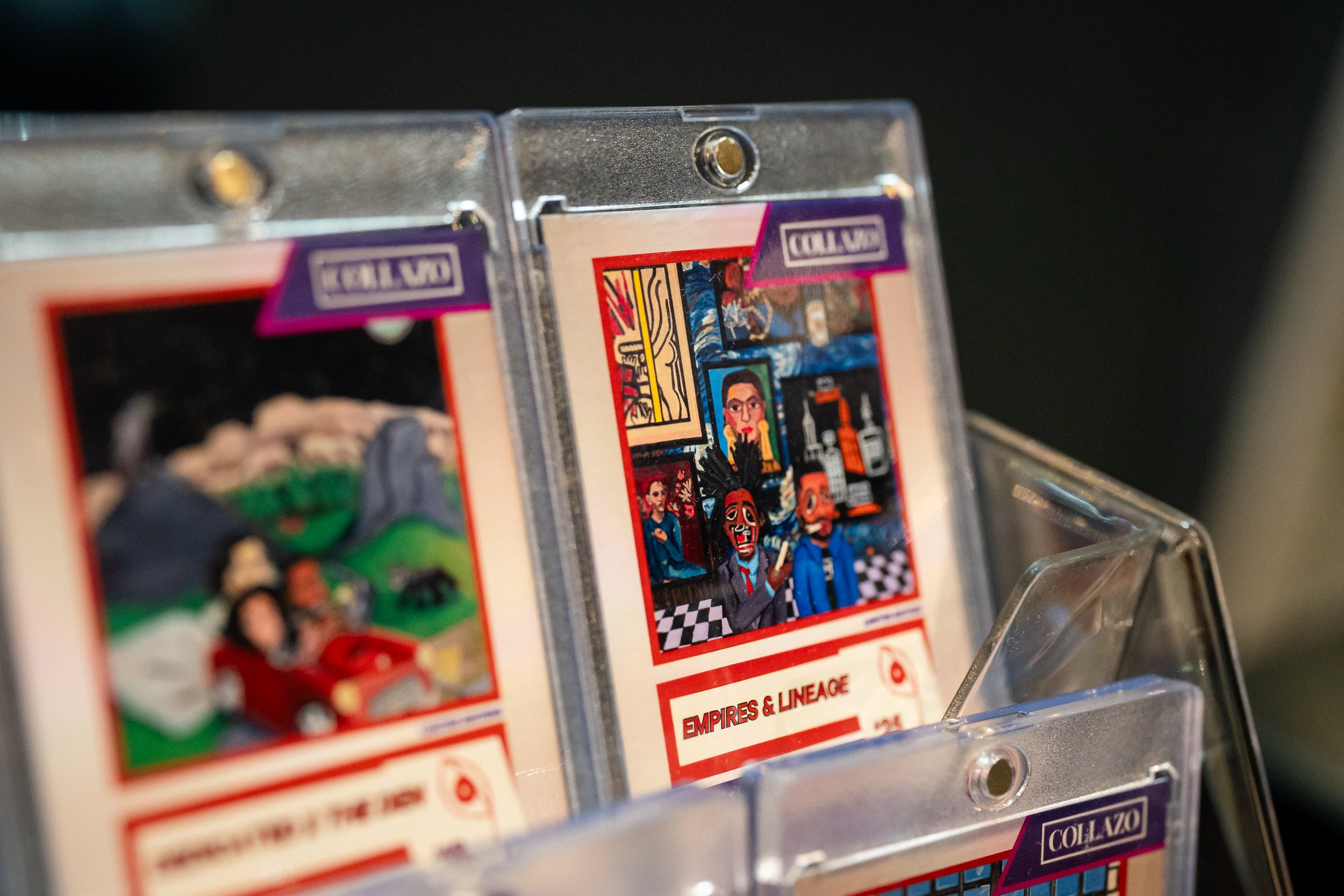 Close-up of plastic cassette tape cases featuring colorful album cover art, placed in a clear plastic display stand.