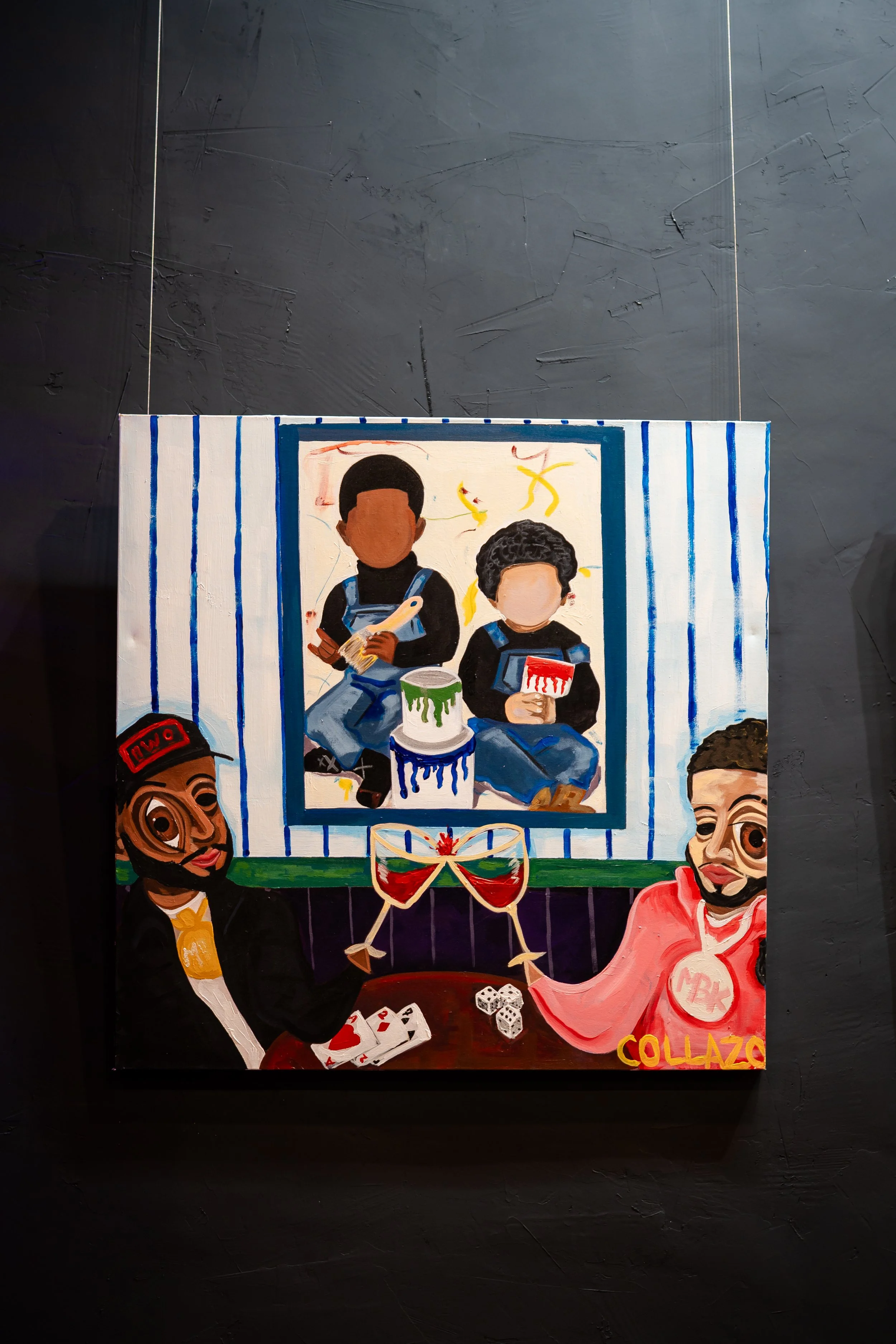 A colorful painting depicting two people clinking glasses filled with red wine, with playing cards and dice on the table. In the background, a smaller painting shows two children sitting with cans of paint and brushes, surrounded by yellow shapes. Th