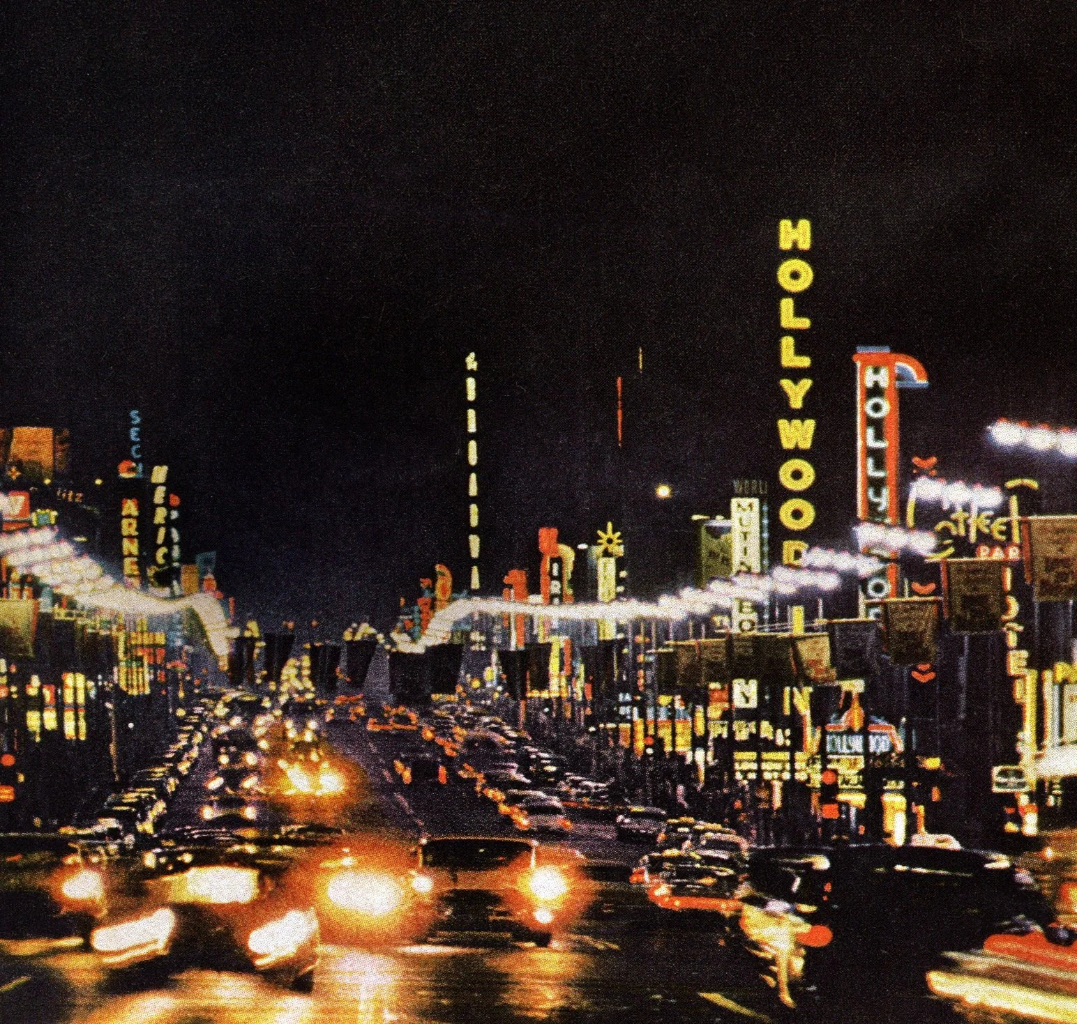 Nighttime street scene with bright neon signs and downtown buildings.