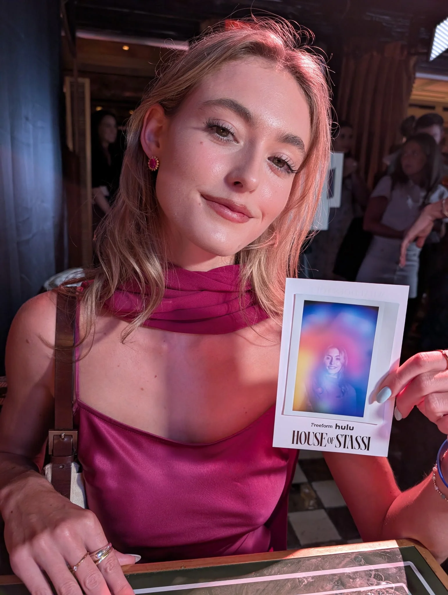 Chloe Bridges holding her aura portrait at the House of Stassi launch event