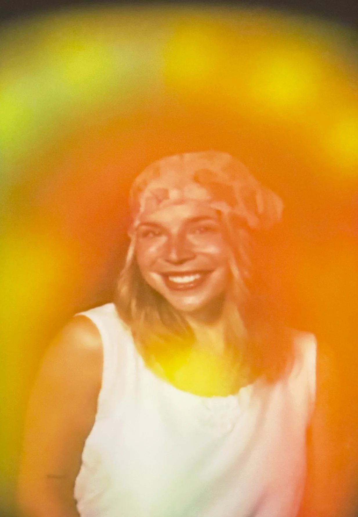 Yellow aura photograph with a golden glow around a smiling woman.