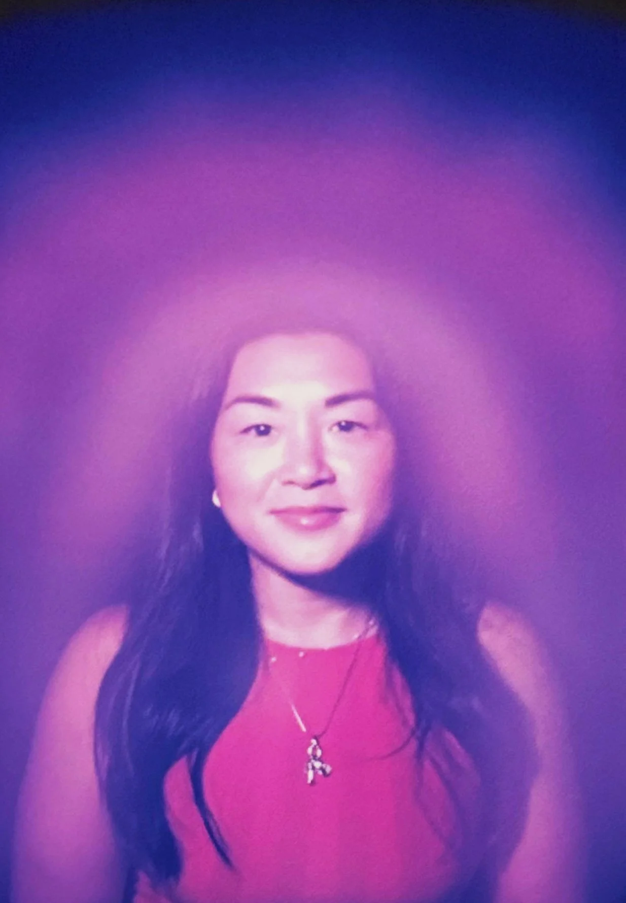 Violet and white aura photograph showing a layered purple glow around a smiling woman.