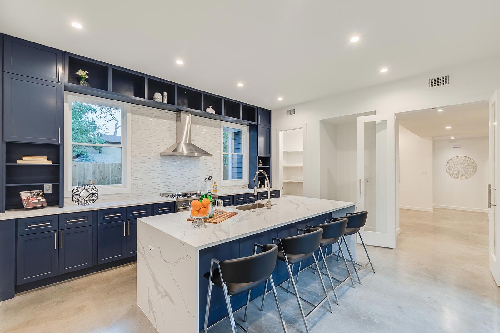 Clean white kitchen with an island and dark blue cabinets