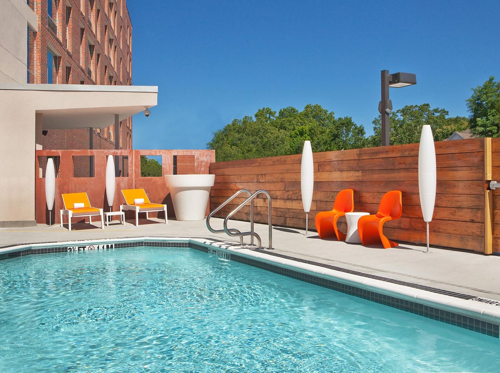 Pool area, lined with bright orange lounge chairs