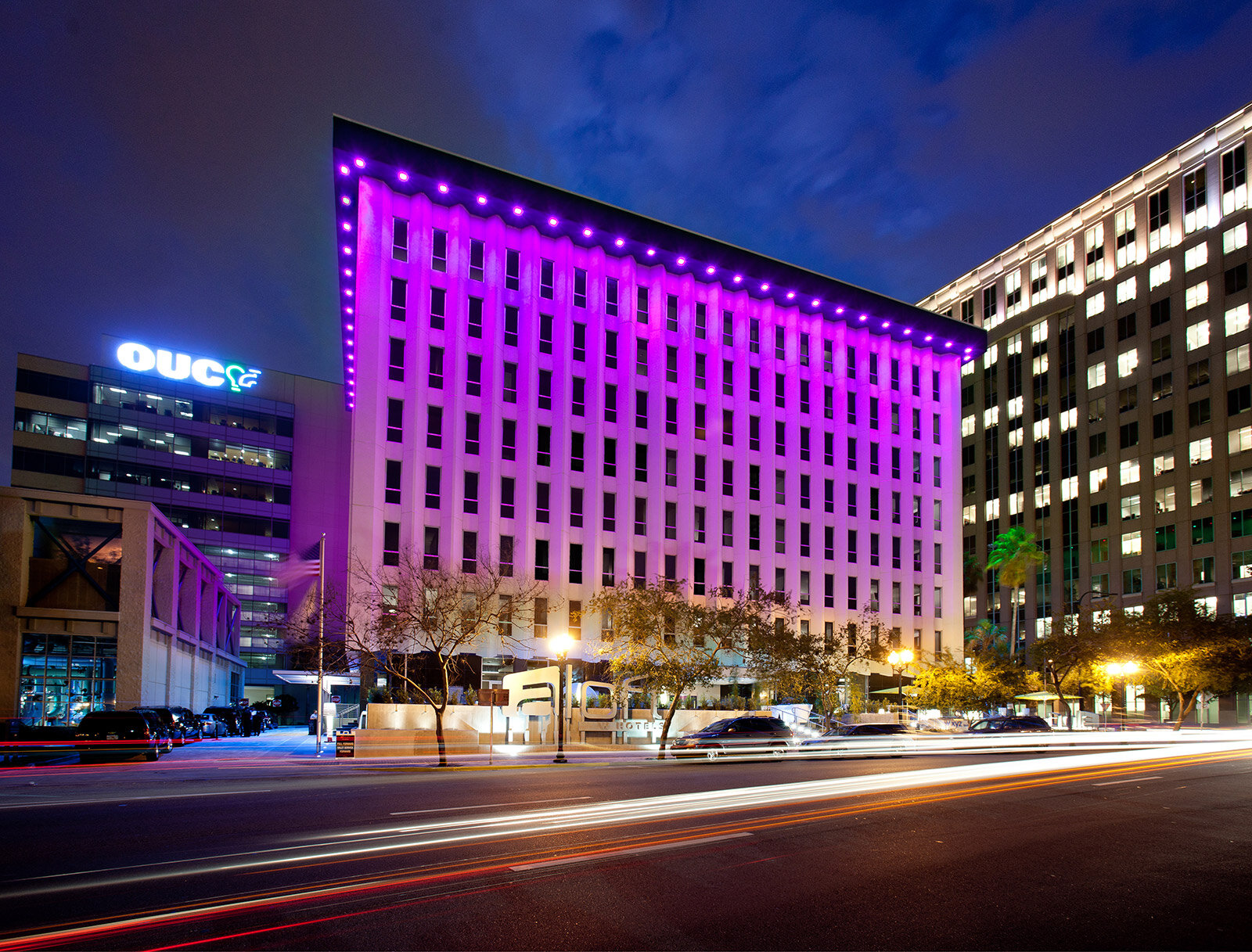 Aloft Hotel exterior at night, lit up in bright pink