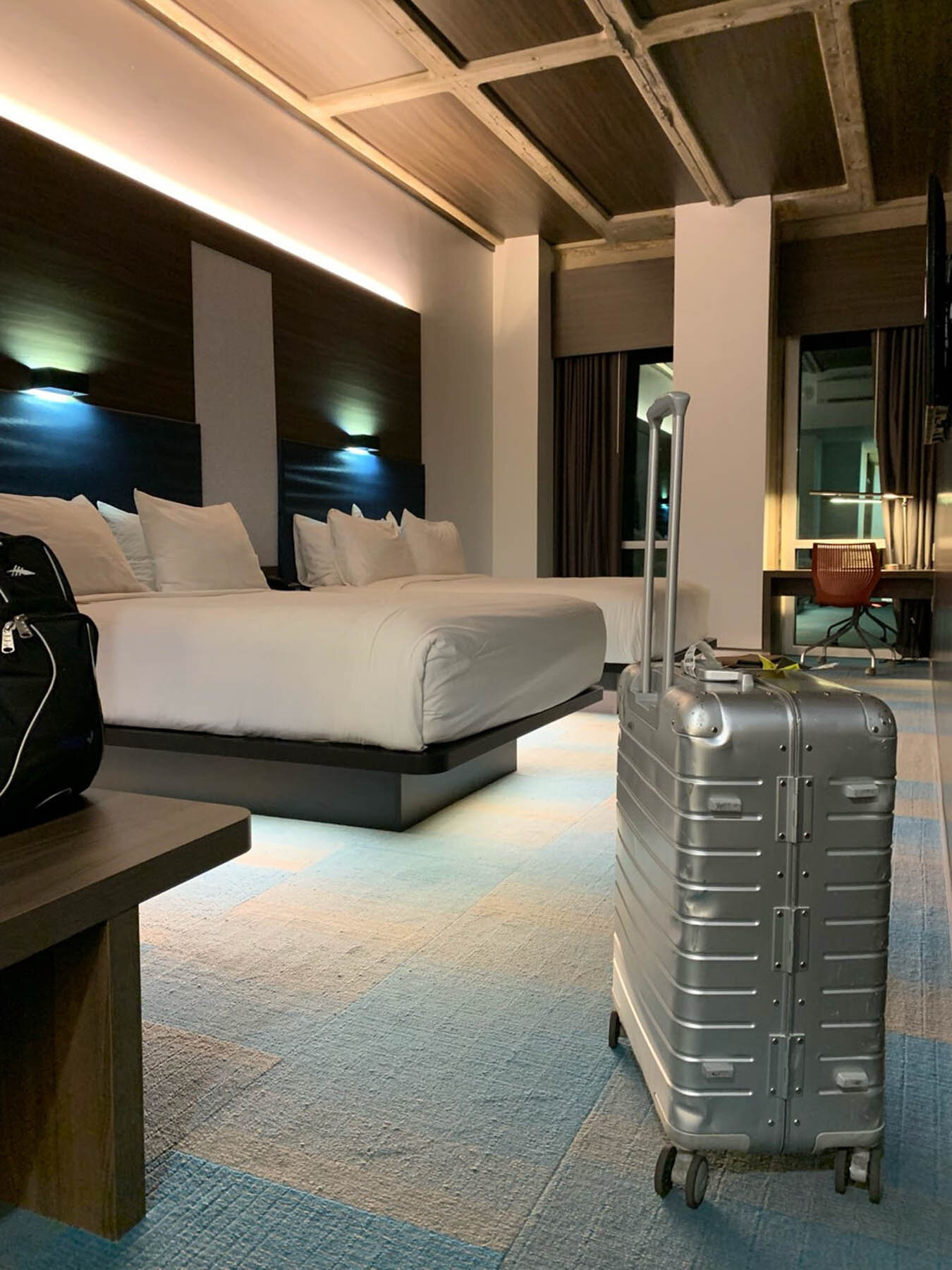 Guest room with a silver suitcase in the foreground