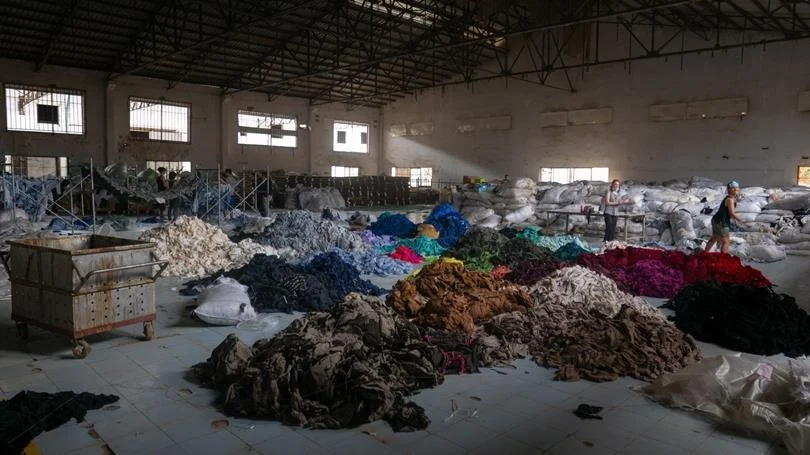 Sorting through hundreds of tons of clothing in an abandoned factory for a social mission called Clothing the Loop.