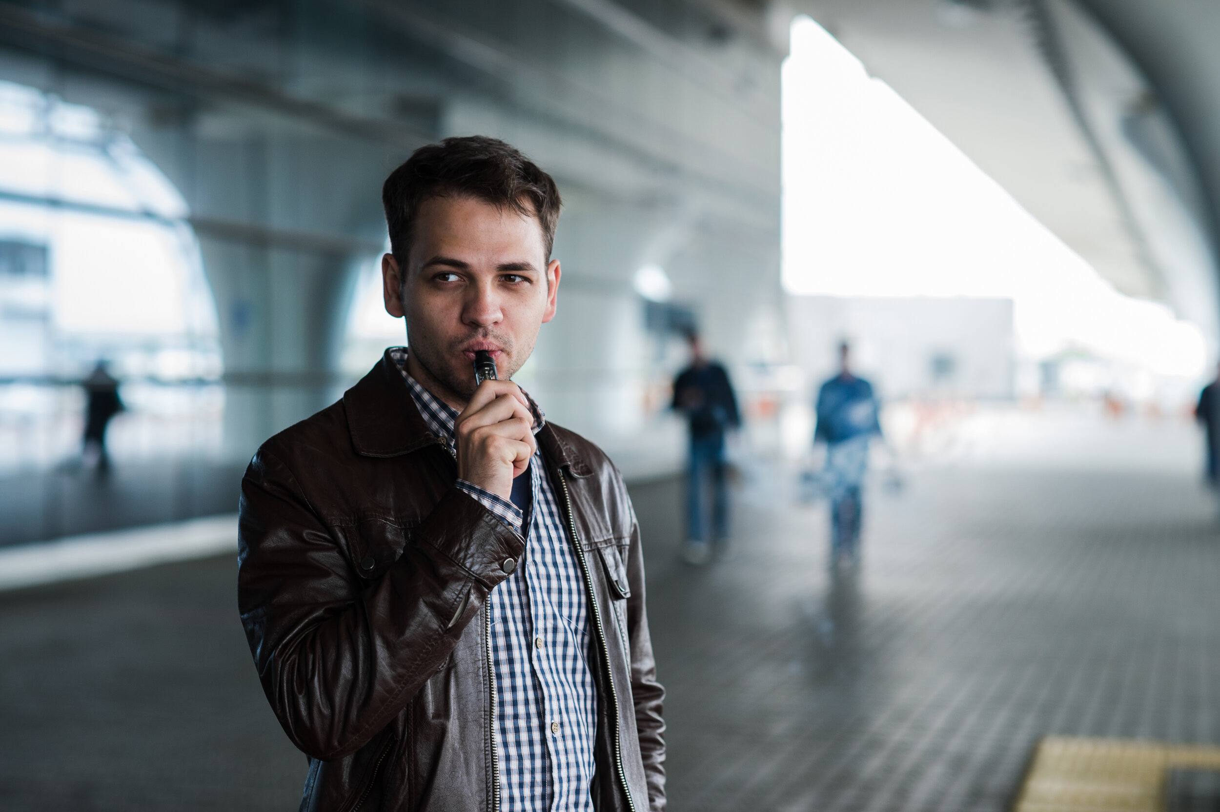 urban-lifestyle-portrait-of-a-man-vaping-near-the-VC2M9NT.jpg