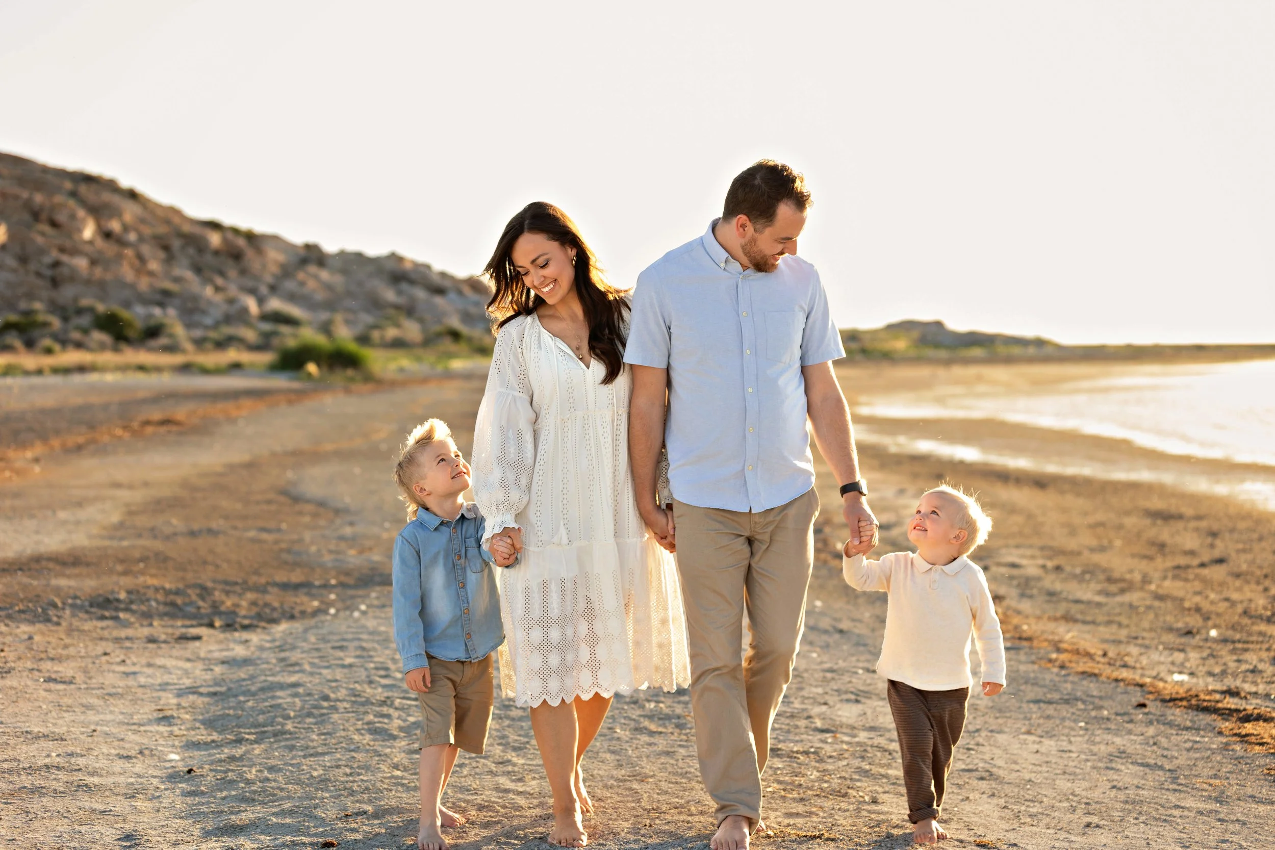 Parents walking with their young children during a sunset family session in Utah