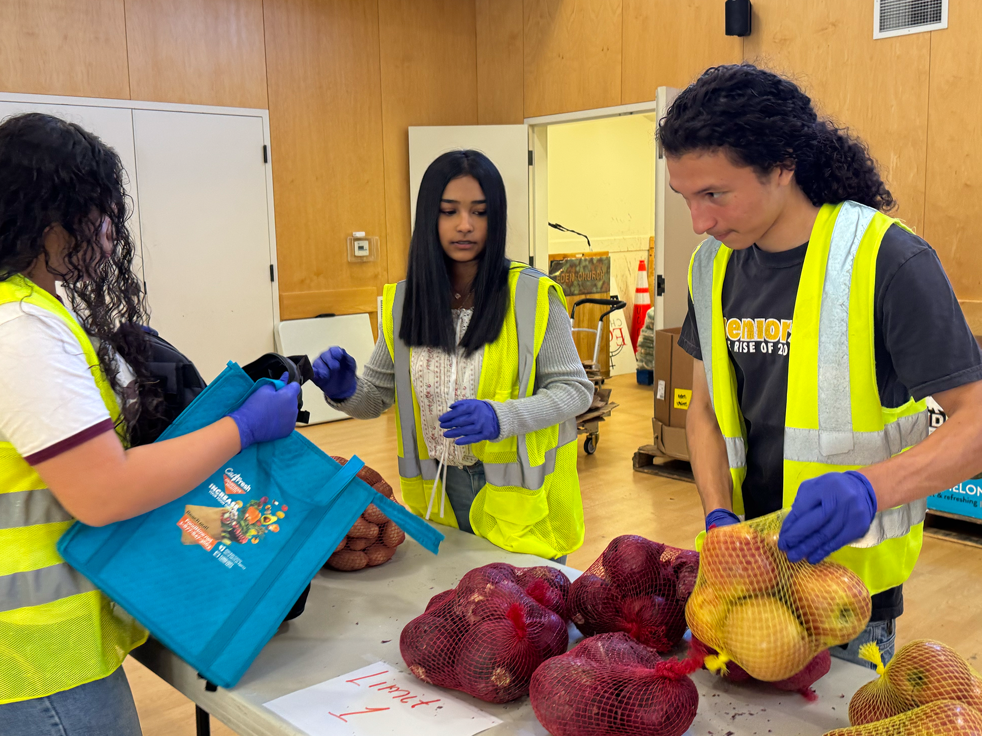Three young people sorting produce
