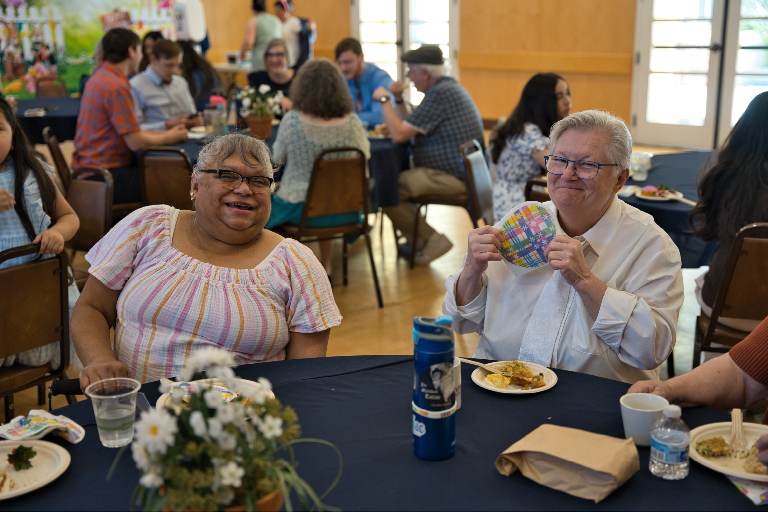 Two people smiling at a dining table