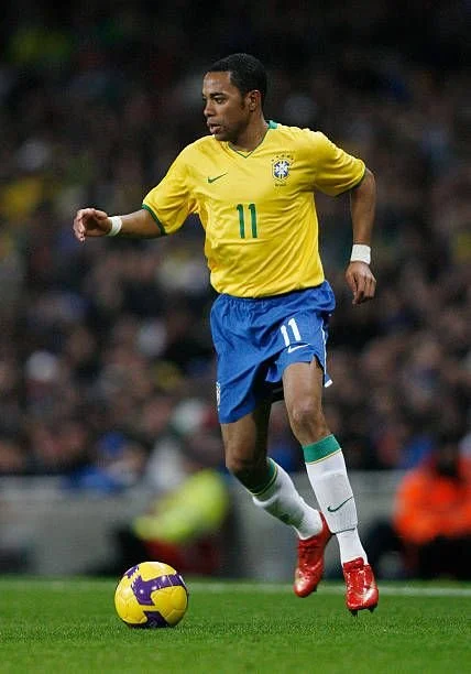 Robinho carrying ball in Seleção yellow kit