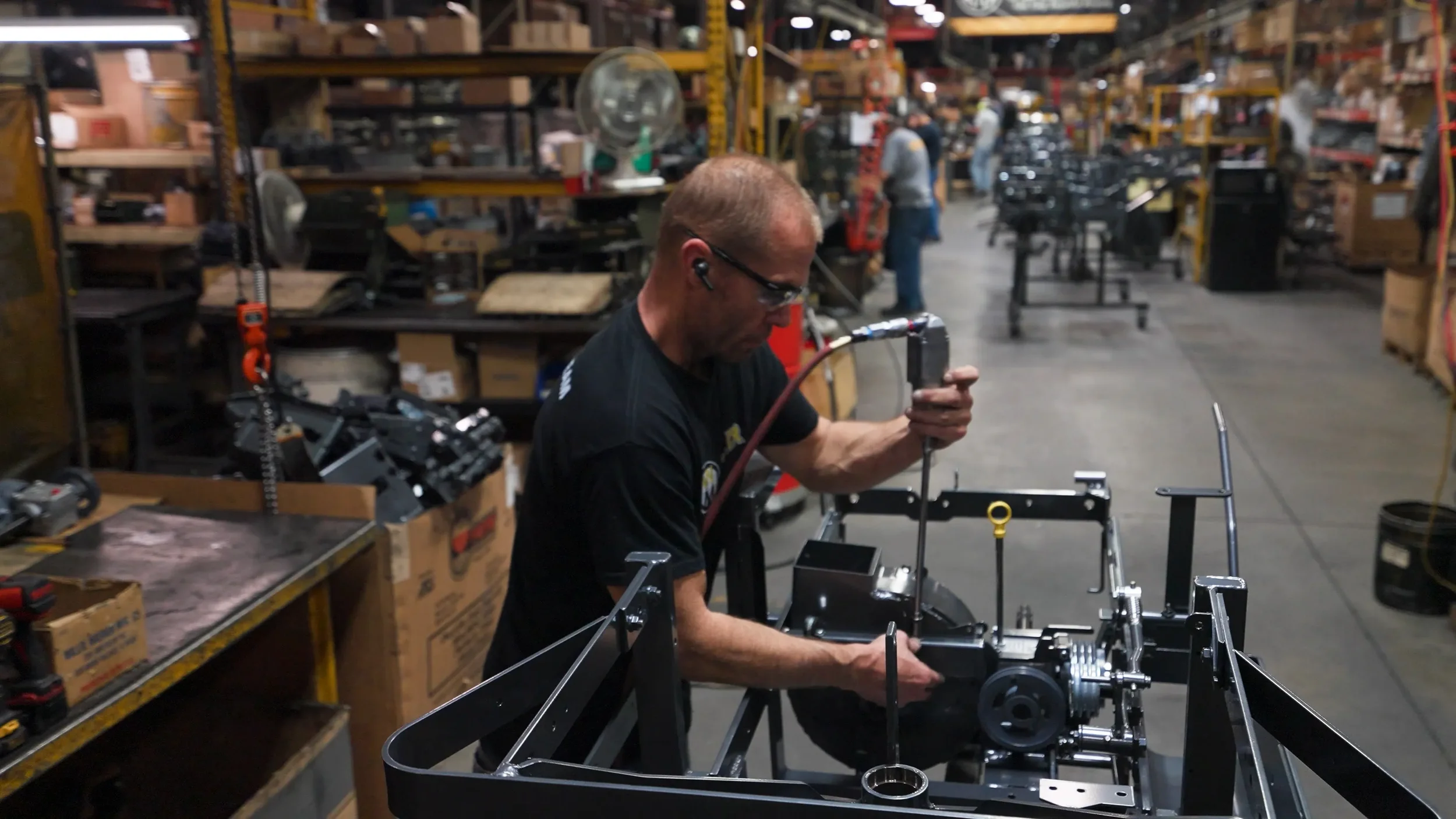 Factory technician assembles the blower houseing for a Walker lawnmower