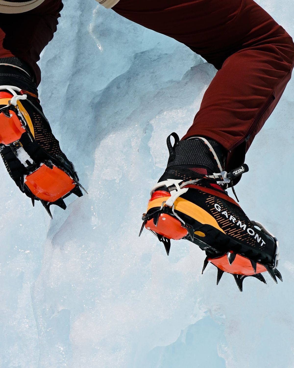 3. Close-up of Garmont mountaineering boots fitted with Petzel crampons stepping into blue glacier ice.jpg