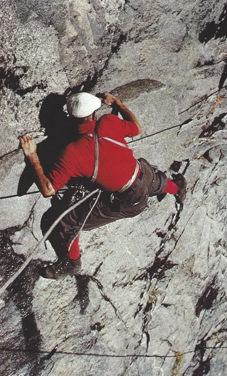 61. Historic colour photograph of a Royal Robbins traversing a granite wall on rope, wearing leather mountaineering boots.jpg