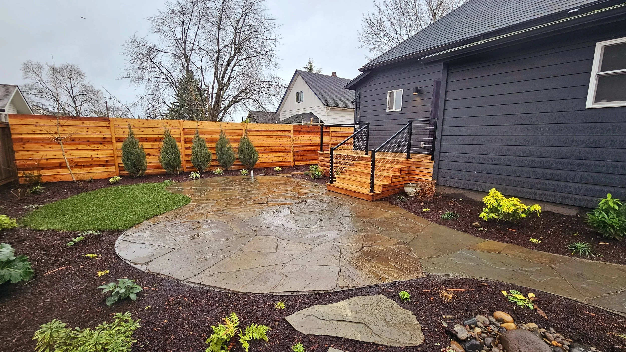 curvy variegated bluestone flagstone patio edged in flat bar steel