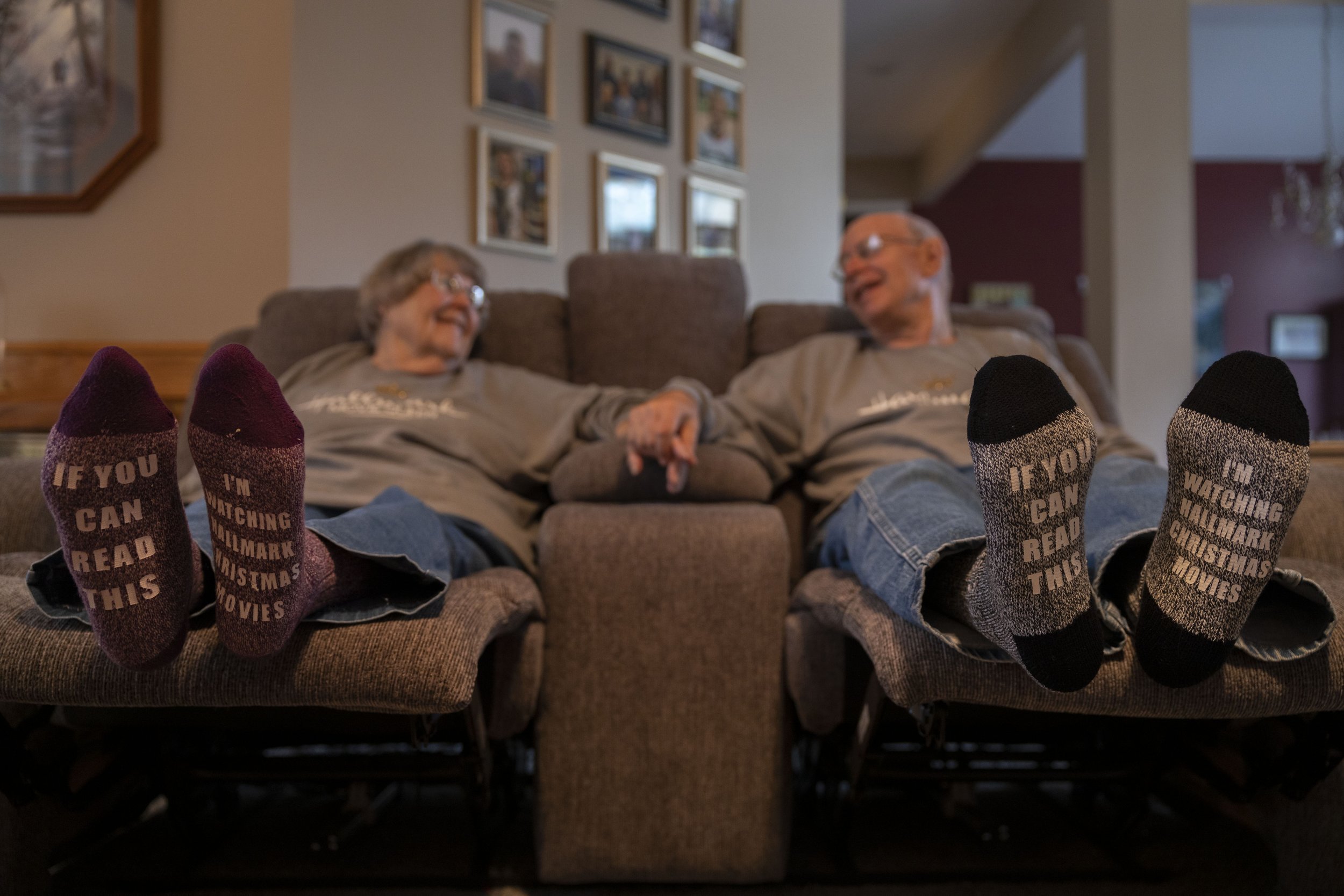  Cheryl and Joe Maggio show off their newly gifted socks while watching a Hallmark Christmas movie at their home on Wednesday, Oct. 27, 2021, in Olathe, Kan. The couple are huge fans of Hallmark Christmas movies and keep a catalog of the movies they 