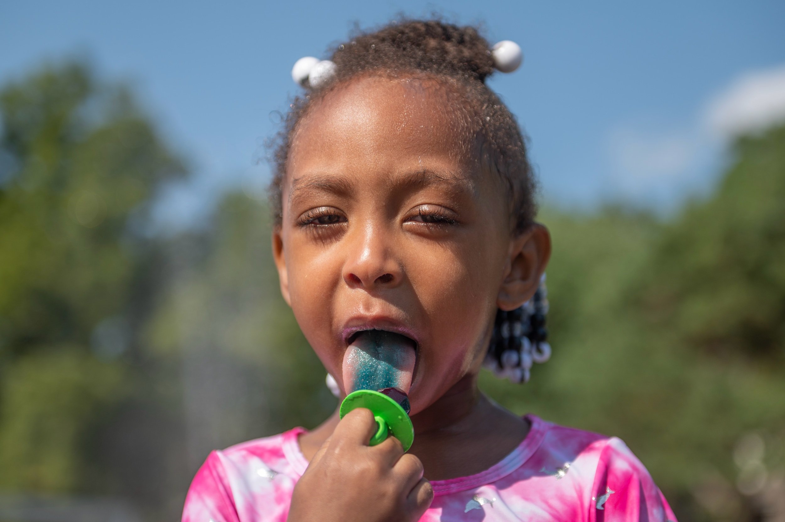  Four-year-old Myanna Mattix, enjoys a ring pop during a hot day at the Gillham Sprayground on Wednesday, June 28, 2023, in Kansas City. 