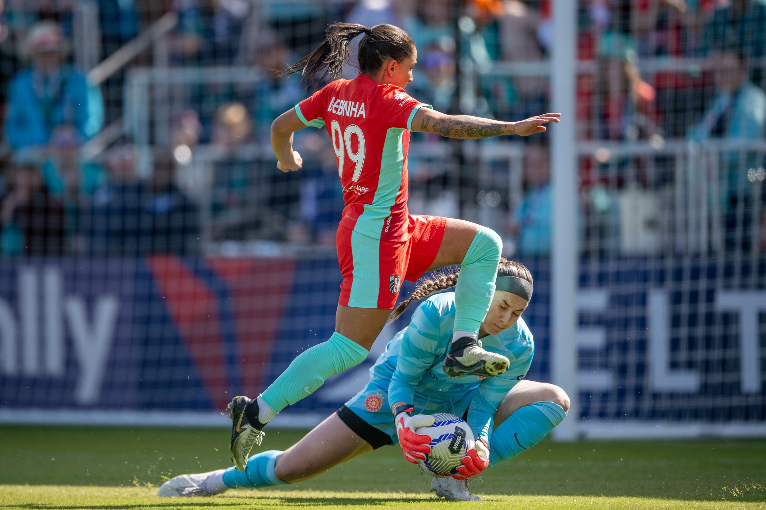 Kansas City Current midfielder Debinha (99) leaps over Portland Thorns FC goalkeeper Shelby Hogan (18) in an attempt to score a goal during the first half of an NWSL match against the Portland Thorns FC at CPKC Stadium on Saturday, March 16, 2024, i