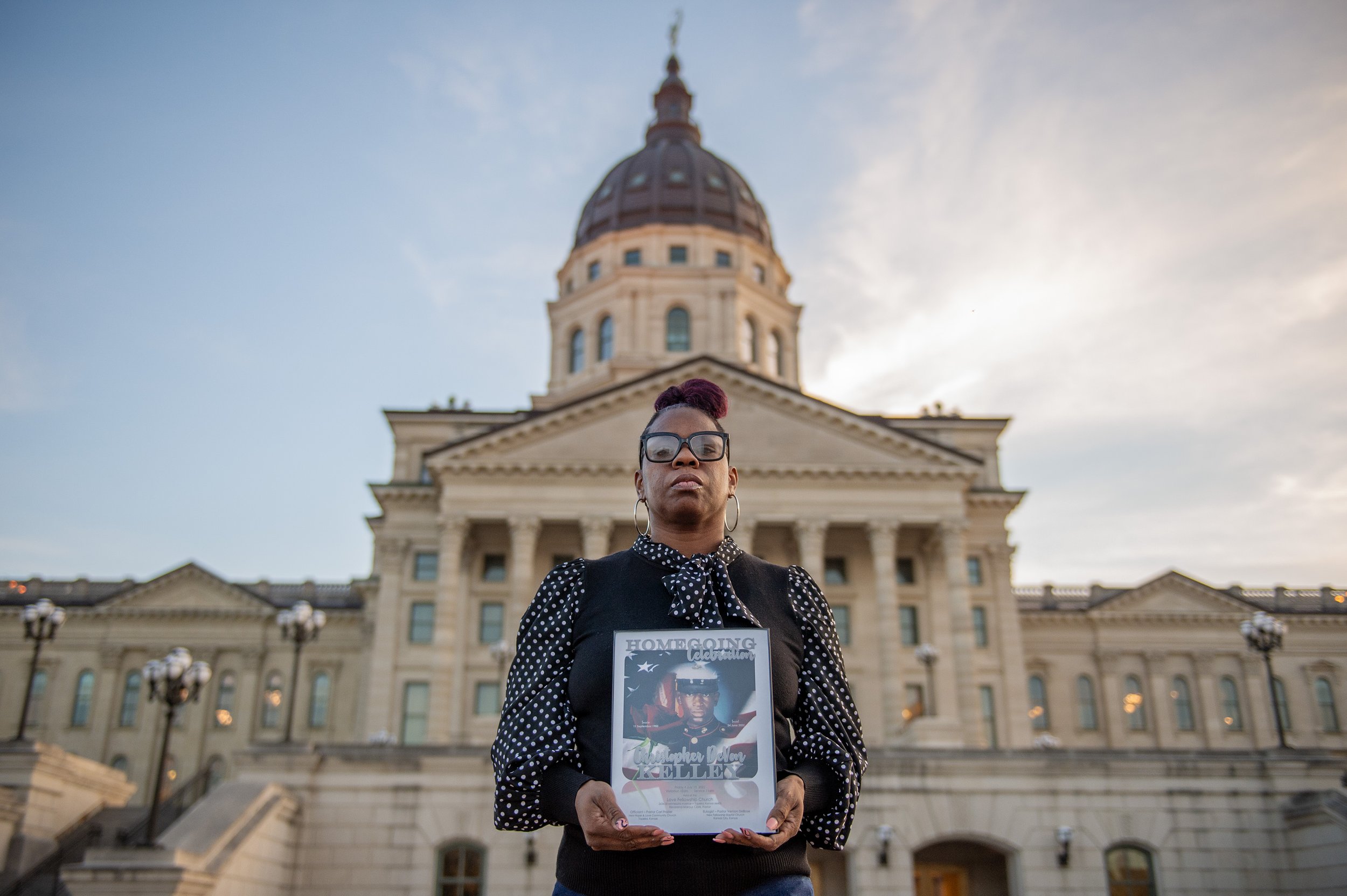  Christian Kelley holds a framed photo of her brother, Christopher DeVon Kelley, in front of the Kansas Statehouse on Tuesday, March 5, 2024, in Topeka, Kansas. Officers shot and killed the Marine Corps veteran in June 2022, and the city of Topeka ha