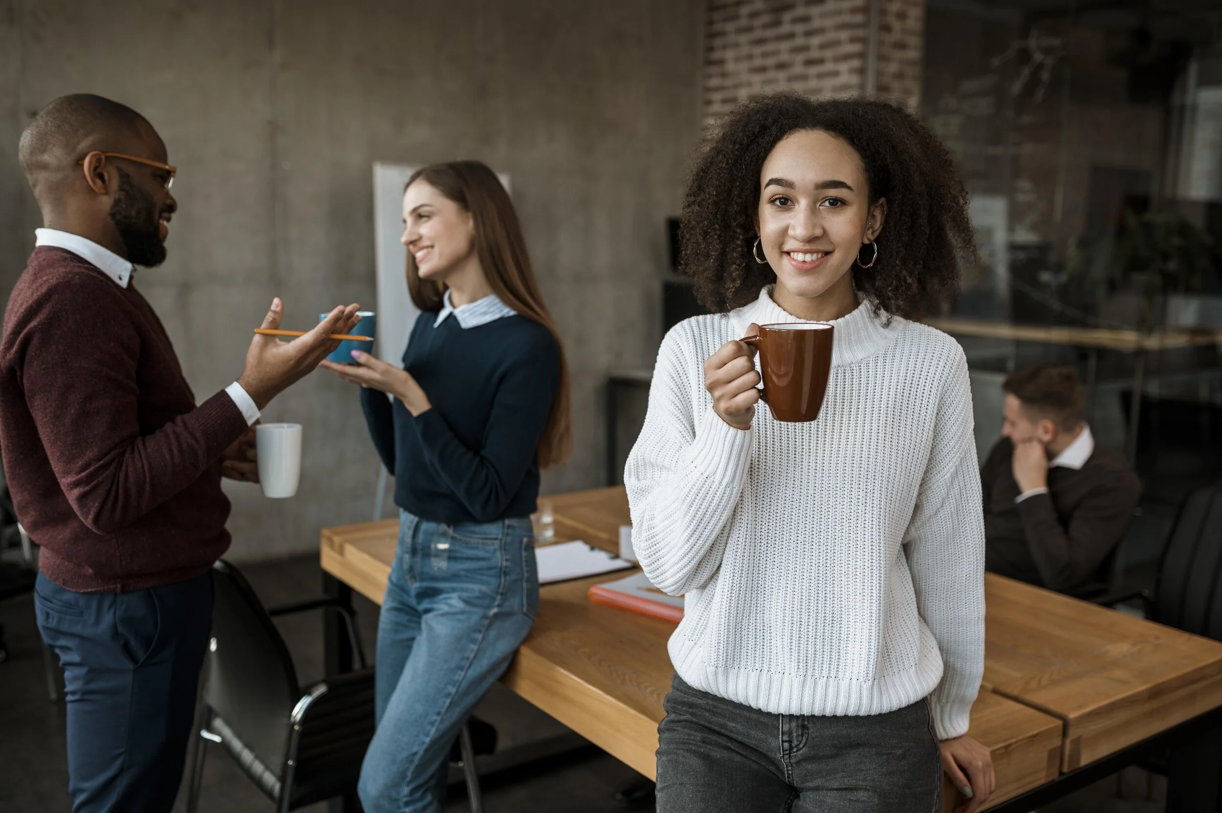 smiley-woman-posing-while-holding-coffee-mug-during-office-meeting.jpg