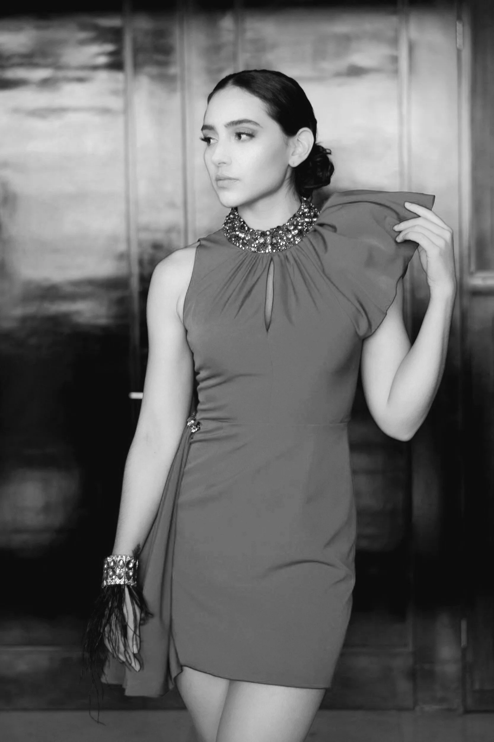 Radiating beauty, a lovely woman with a low updo dons a chic off-the-shoulder cocktail gown for her special event. Her stunning appearance captivates, showcasing a perfect blend of style and grace.