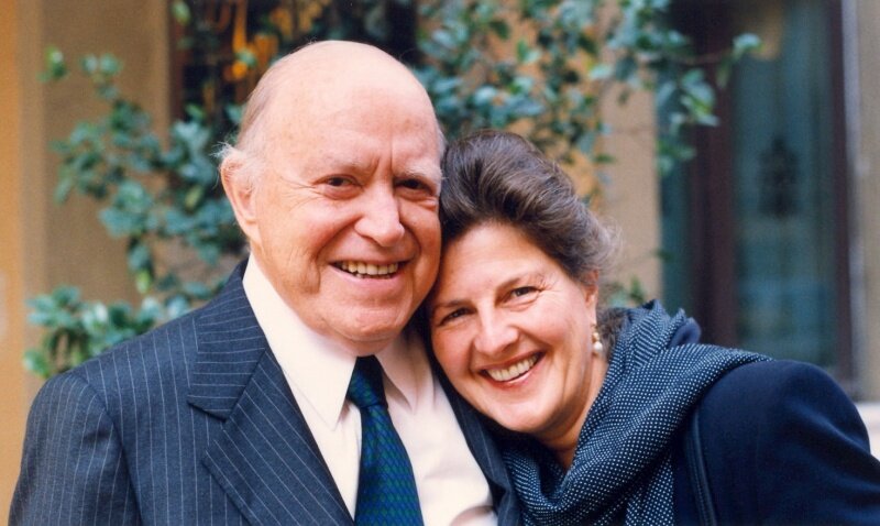 Portrait of John and Maria Kluge, posed together smiling.