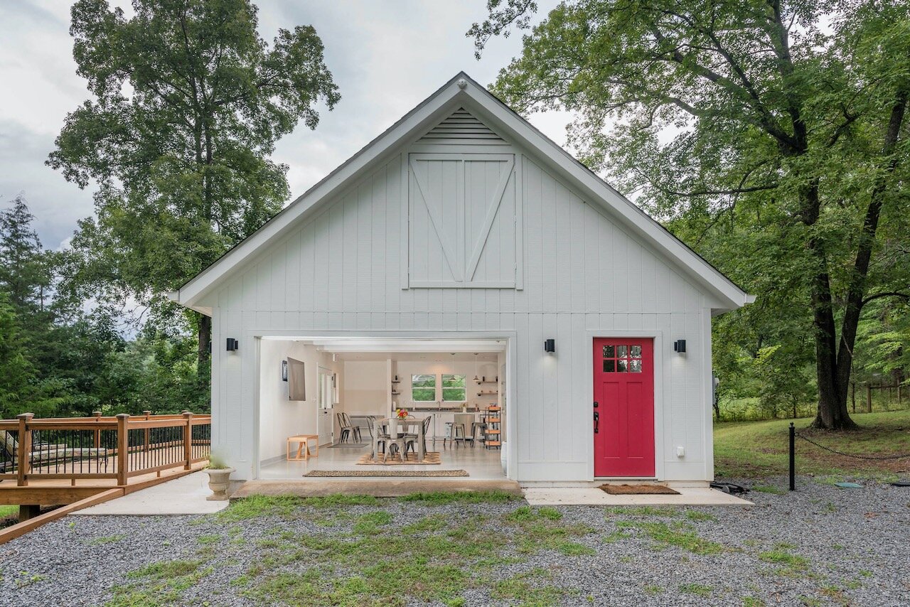 The First Lady's Food Lab, the structure is white with a red entry door and white window framed garage door.