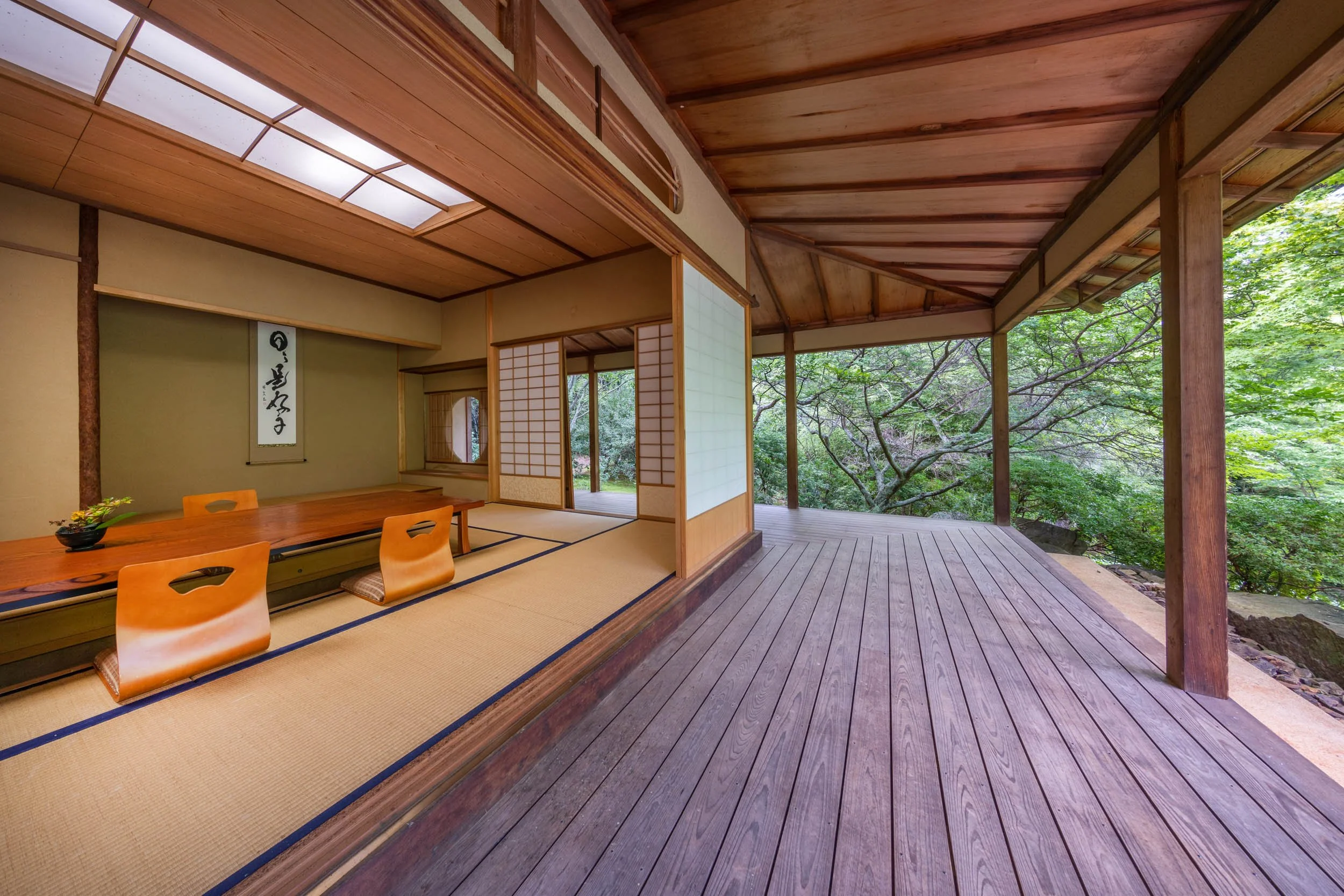 The interior of the Morven Japanese Garden Summer House, with sliding panel doors, woven floor mats, and a floor seated table.