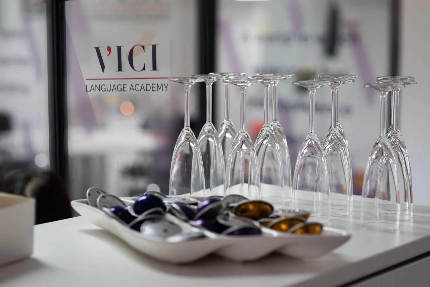 Empty wine glasses arranged upside down on a table at VICI Language Academy's event captured by Newbury event photographer