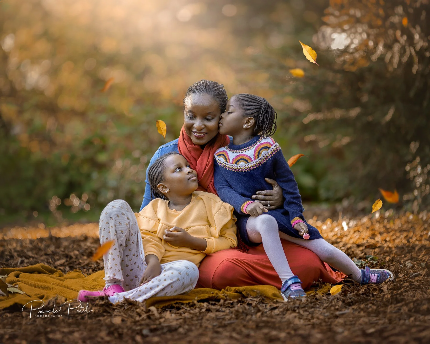 Mum with two girls on blanket in autumn, captured at autumn photoshoot in reading by family photographer.