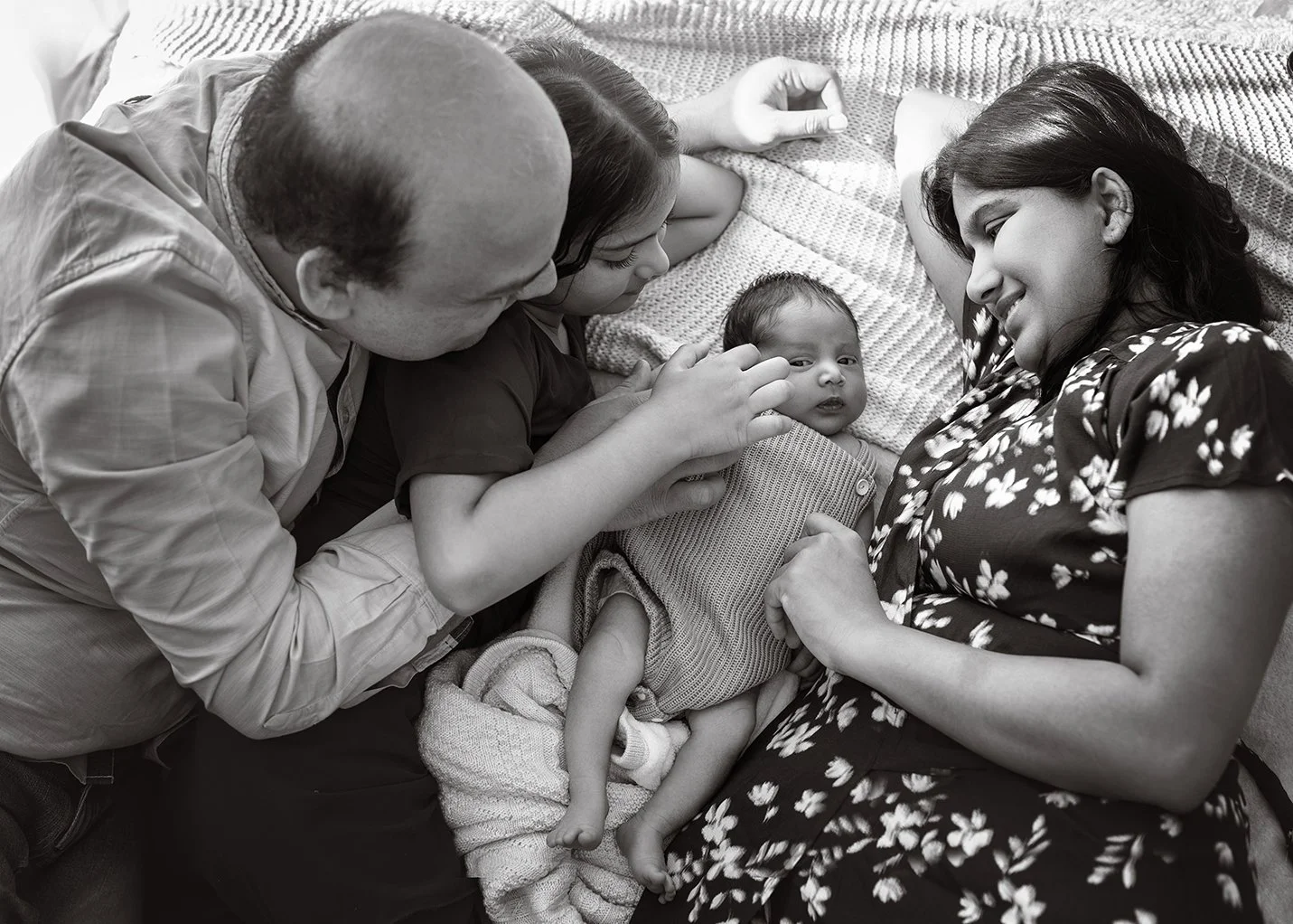 a family of 4 admiring the newborn baby.jpg