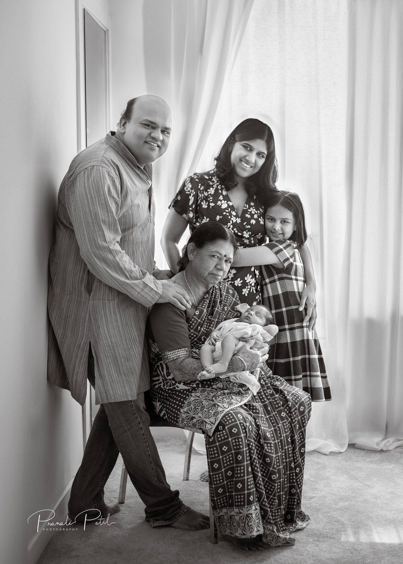 Newborn photoshoot in Reading berkshire, capturiung a multi-generational family portrait featuring six people, including a baby and grandmama.