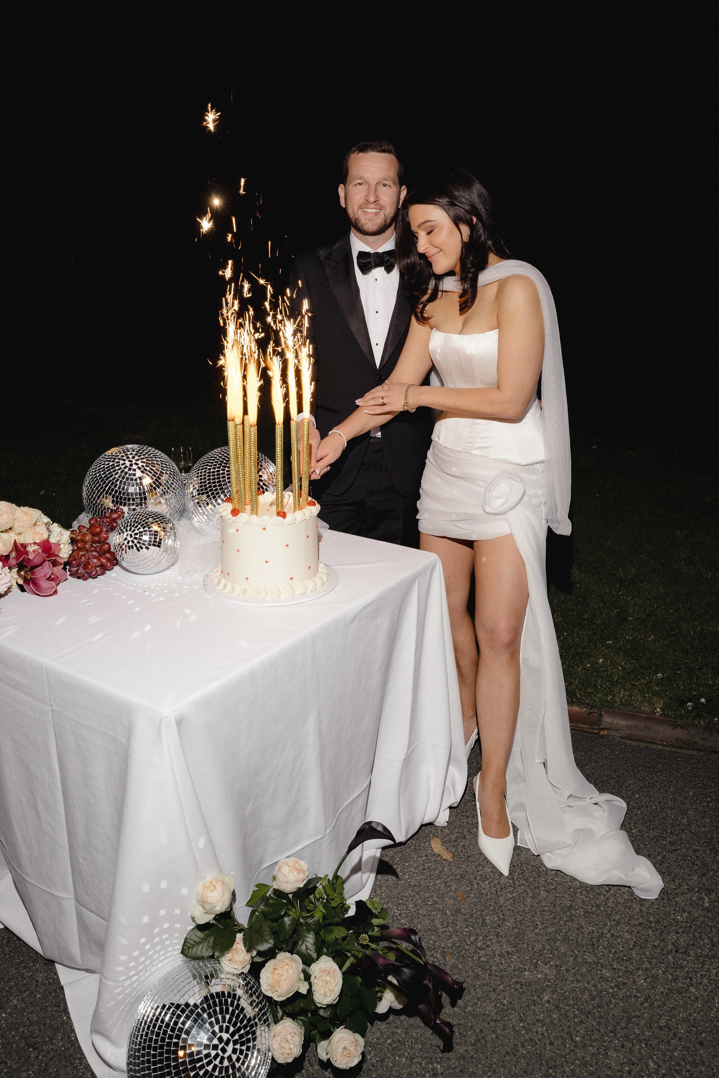Bride and Groom cut the cake at Gardens House in the Botanical Gardens surrounded by Flowers and Styling by Petal and Sage