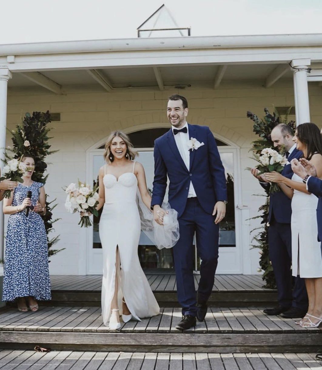 Bride and Groom walk down the aisle at The Farm Yarra Valley with florals created by Petal and Sage