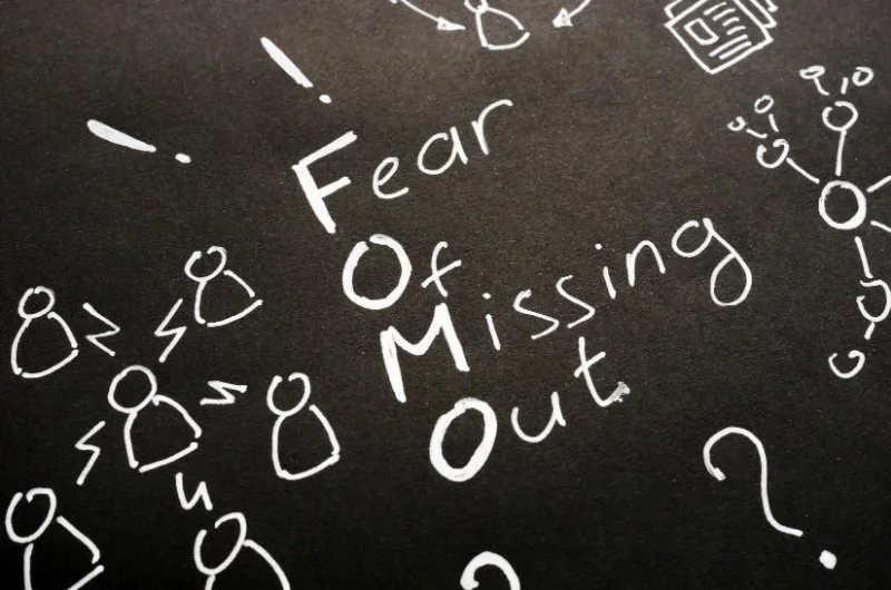 Chalkboard illustration showing “Fear of Missing Out (FOMO)” concept, representing financial FOMO and the risks of following investment trends