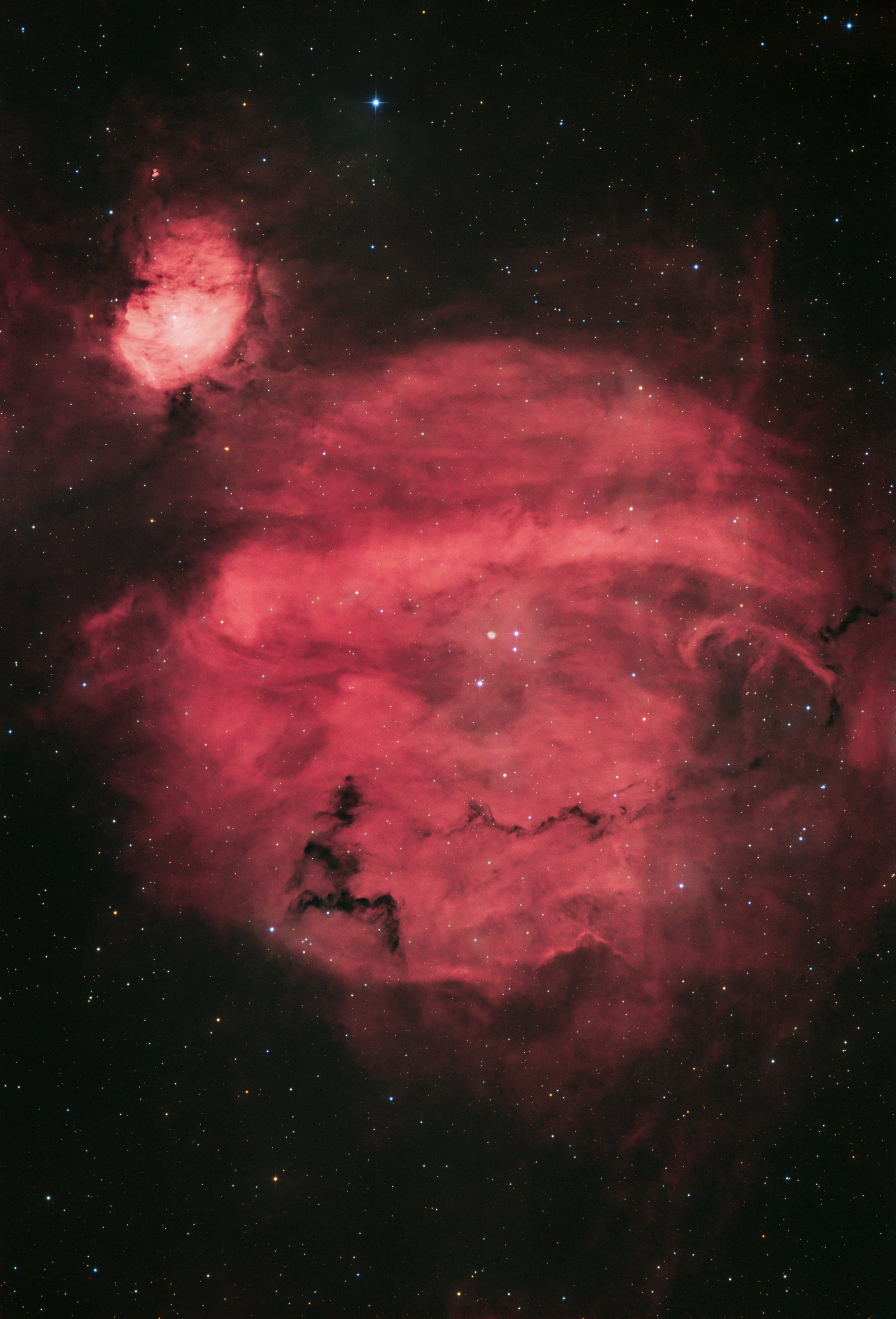 Wide-field Hα image of the Sh2-231 to Sh2-235 emission nebula complex in the Perseus Arm, showing red glowing hydrogen clouds, dark dust lanes, and scattered stars against a black sky, captured from Cork City, Ireland.