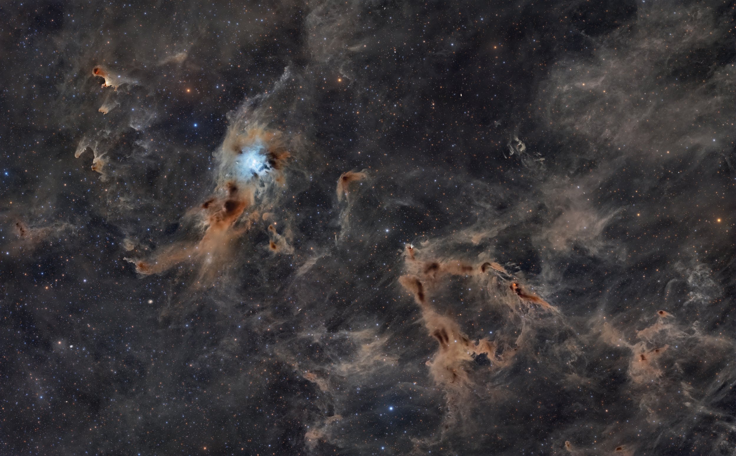 Wide-field mosaic of the Iris Nebula NGC 7023 glowing blue at center, surrounded by faint brown and gray interstellar dust clouds against a dense star-filled background.