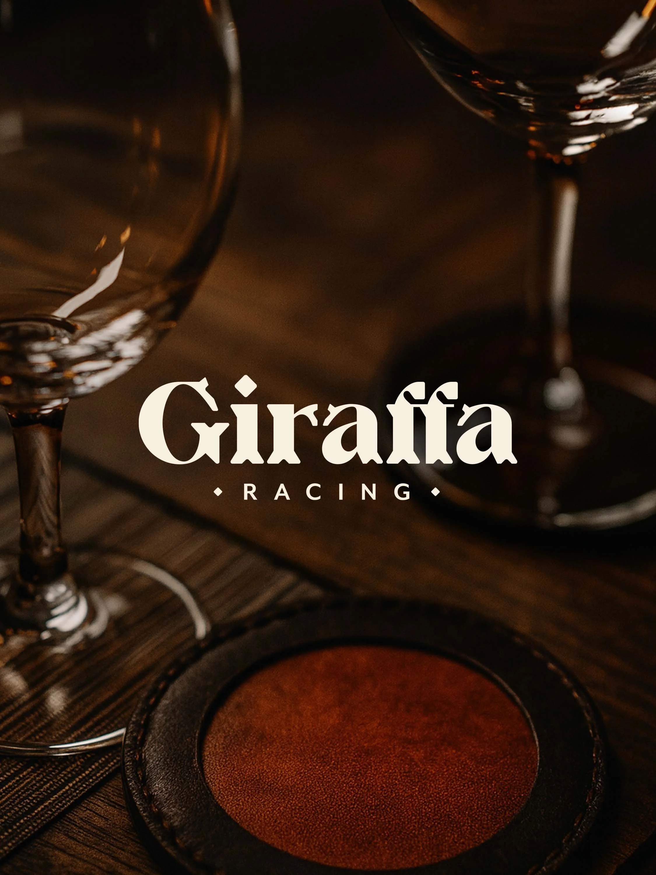 An image of the logotype in white on top of an image of a close-up collection of wine glasses