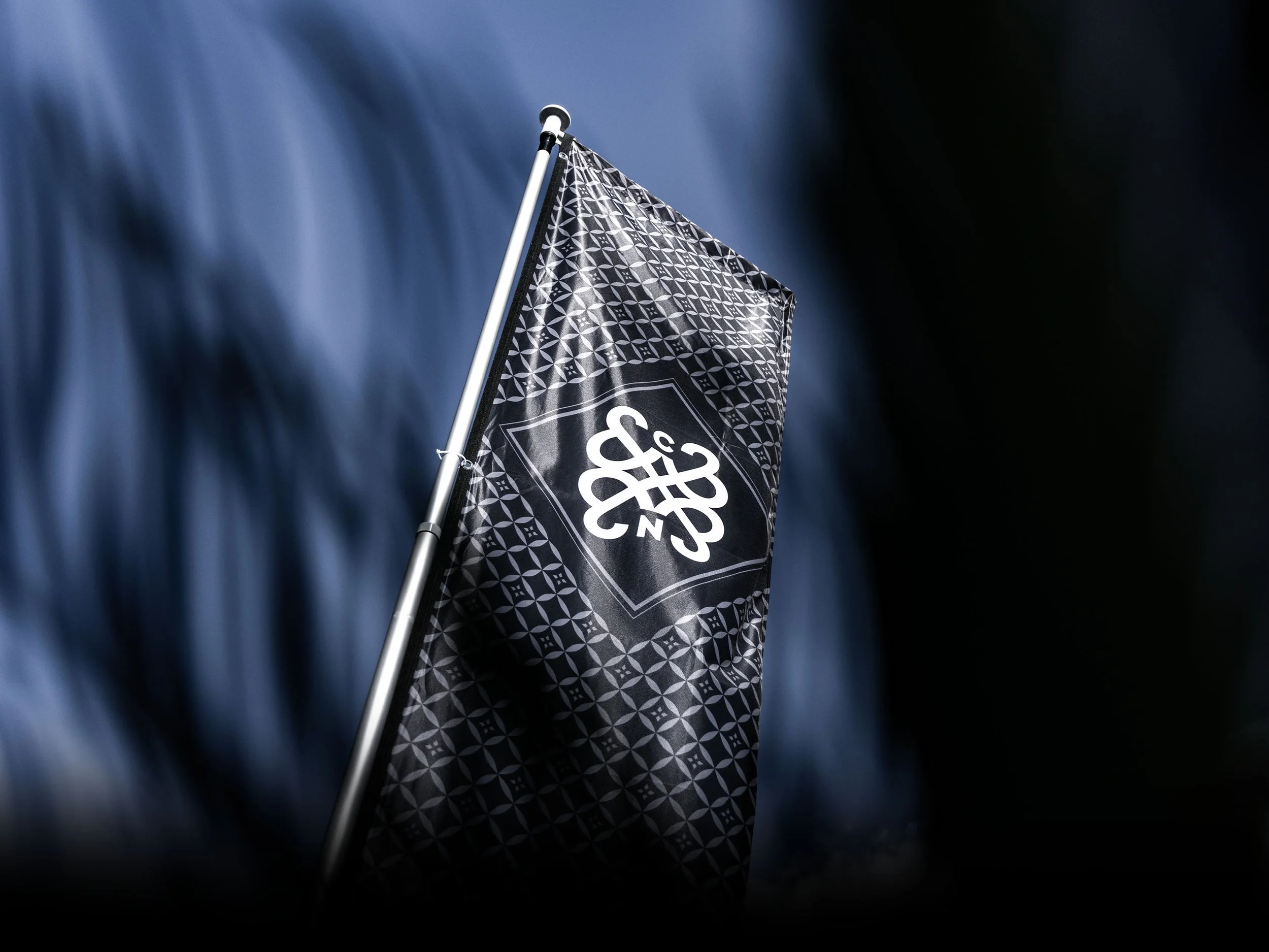 Image of a C&N flag, featuring the pattern and emblem in black and white