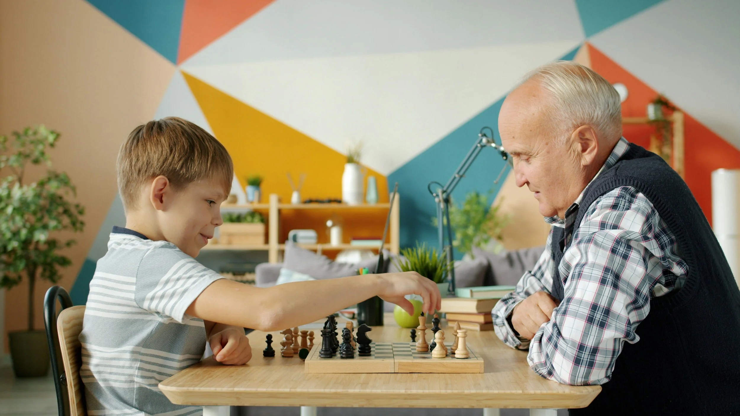 retiree playing chess with grandson