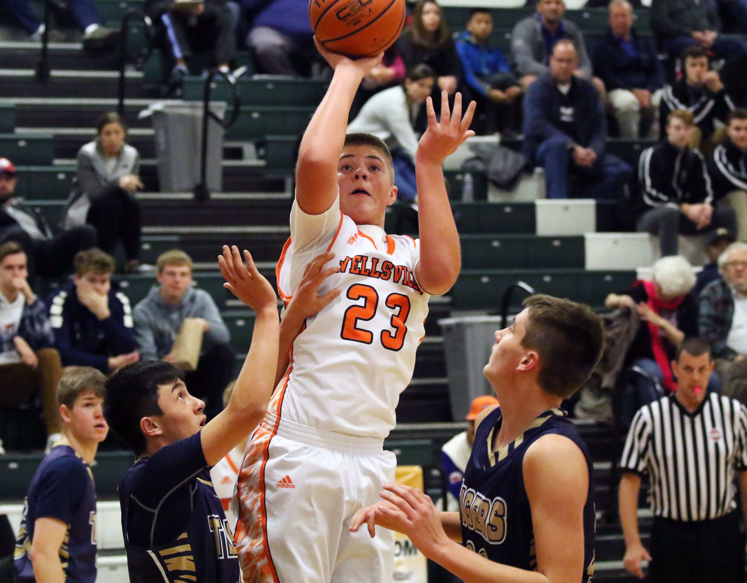  Wellsville’s Logan Dunbar (23) puts up a shot, as the North Penn-Mansfield defense swarms to make a play during Monday afternoon’s championship game of the Josh Palmer Holiday Classic in Elmira. [Chris Brooks/WellsvilleSports.com] 