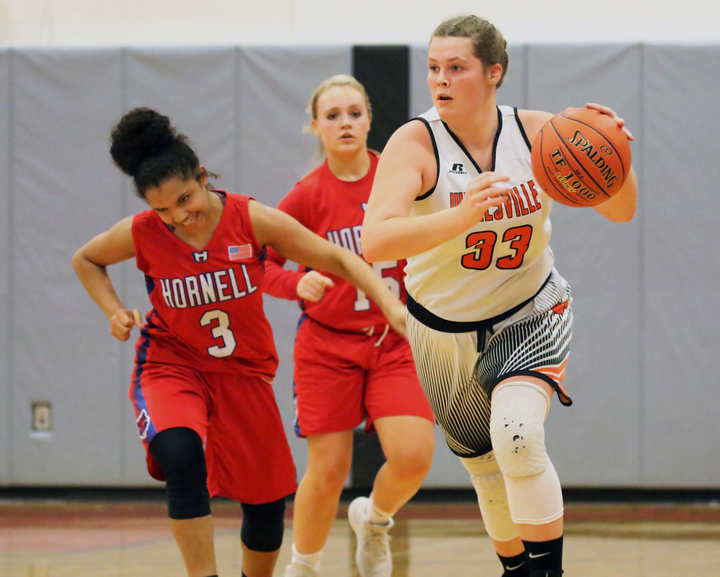  Wellsville senior Regan Marsh (33) pushes the pace down the court as the Hornell defense races back to challenge during Friday’s home contest. [Chris Brooks/WellsvilleSports.com] 