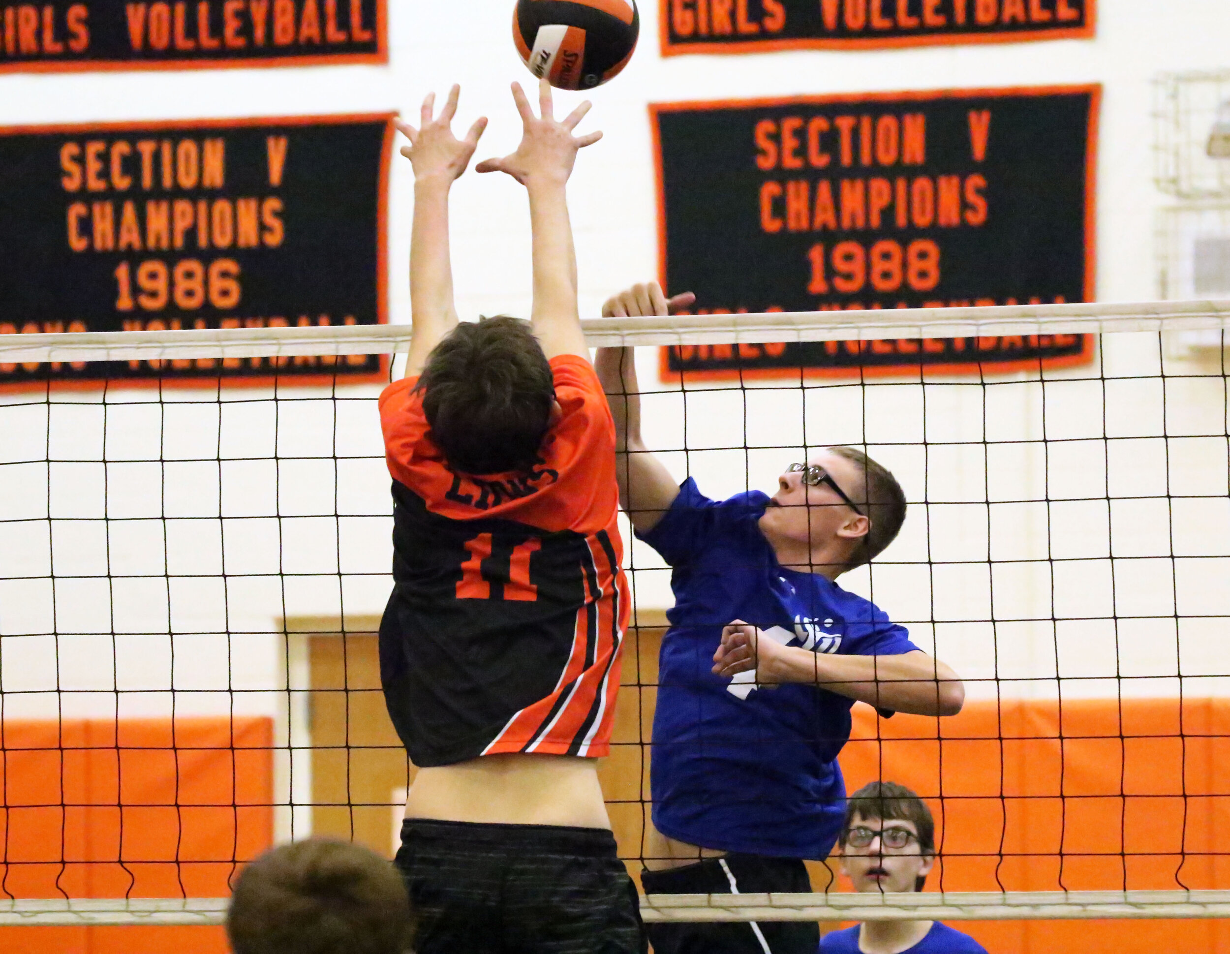  Cuba-Rushford’s Joey Frederick, off-center, goes up to return the ball to the Lions, as Wellsville’s Walker Waldon (11) leaps up for the block during Thursday night’s clash in Wellsville. [Chris Brooks/WellsvilleSports.com] 
