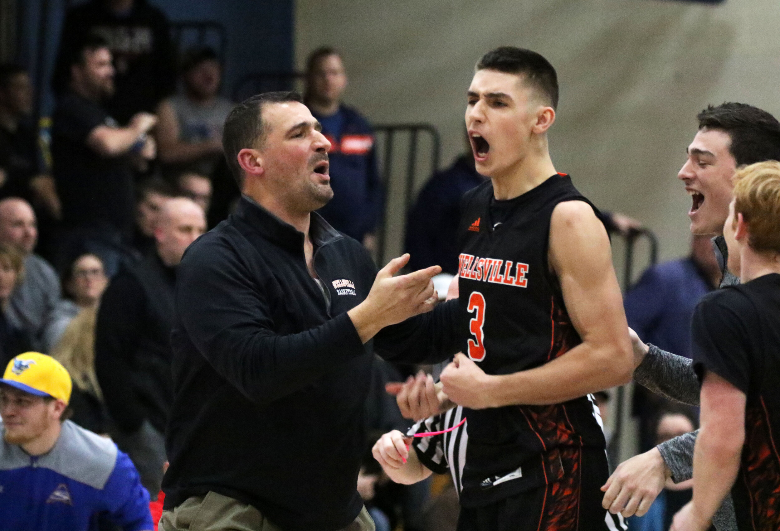  Wellsville senior Max Jusianiec (3) celebrates on the sidelines with his father, Lions interim head coach Jerry Jusianiec, left, after he sealed a 46-45 victory over Hornell with a buzzer-beating block in the Barkley Showcase’s nightcap on Friday at
