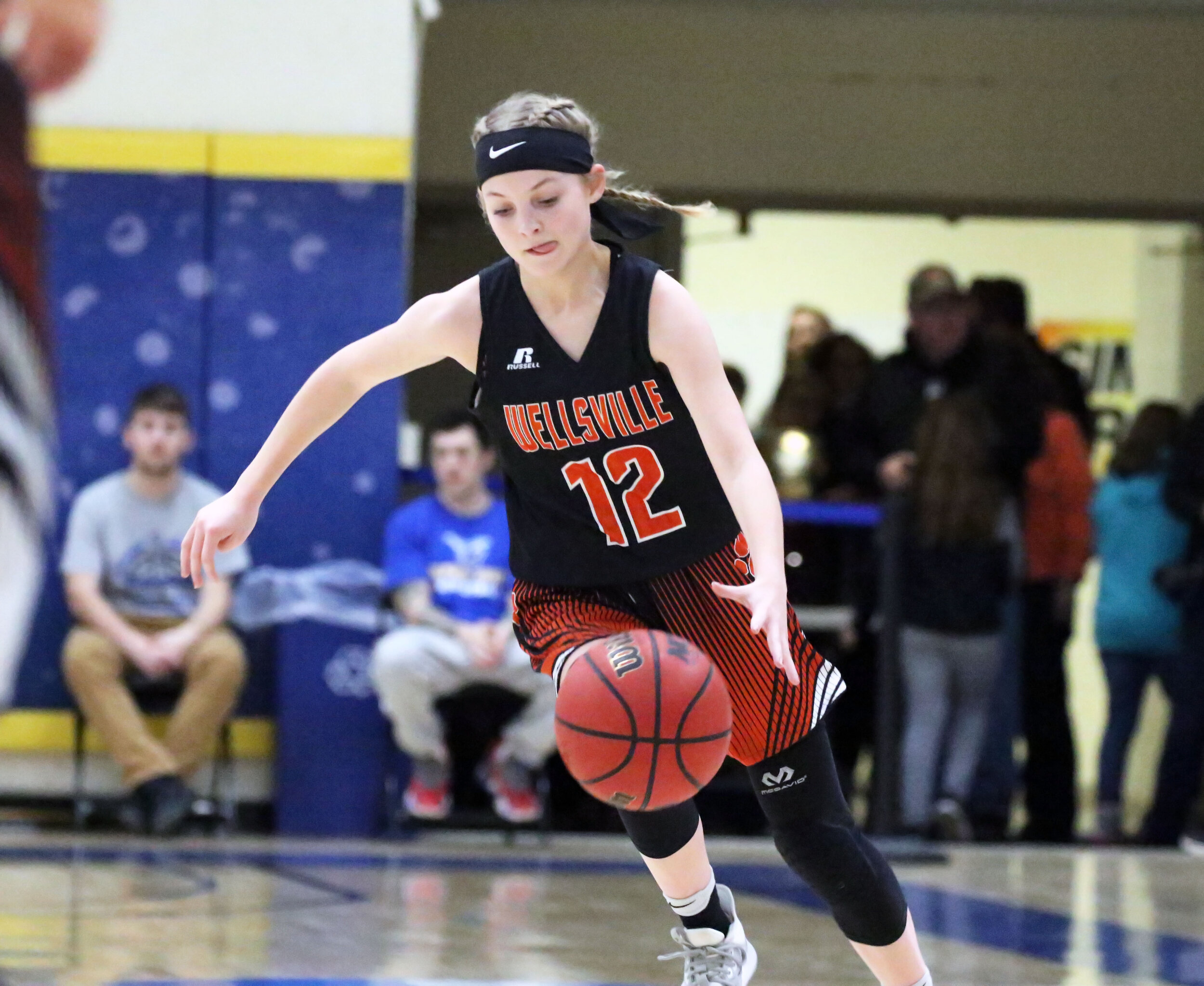  Wellsville sophomore Emily Costello (12) dribbles down the baseline toward the basket during Friday night’s clash against Hornell at the Barkley Showcase at Alfred State College. [Chris Brooks/WellsvilleSports.com] 