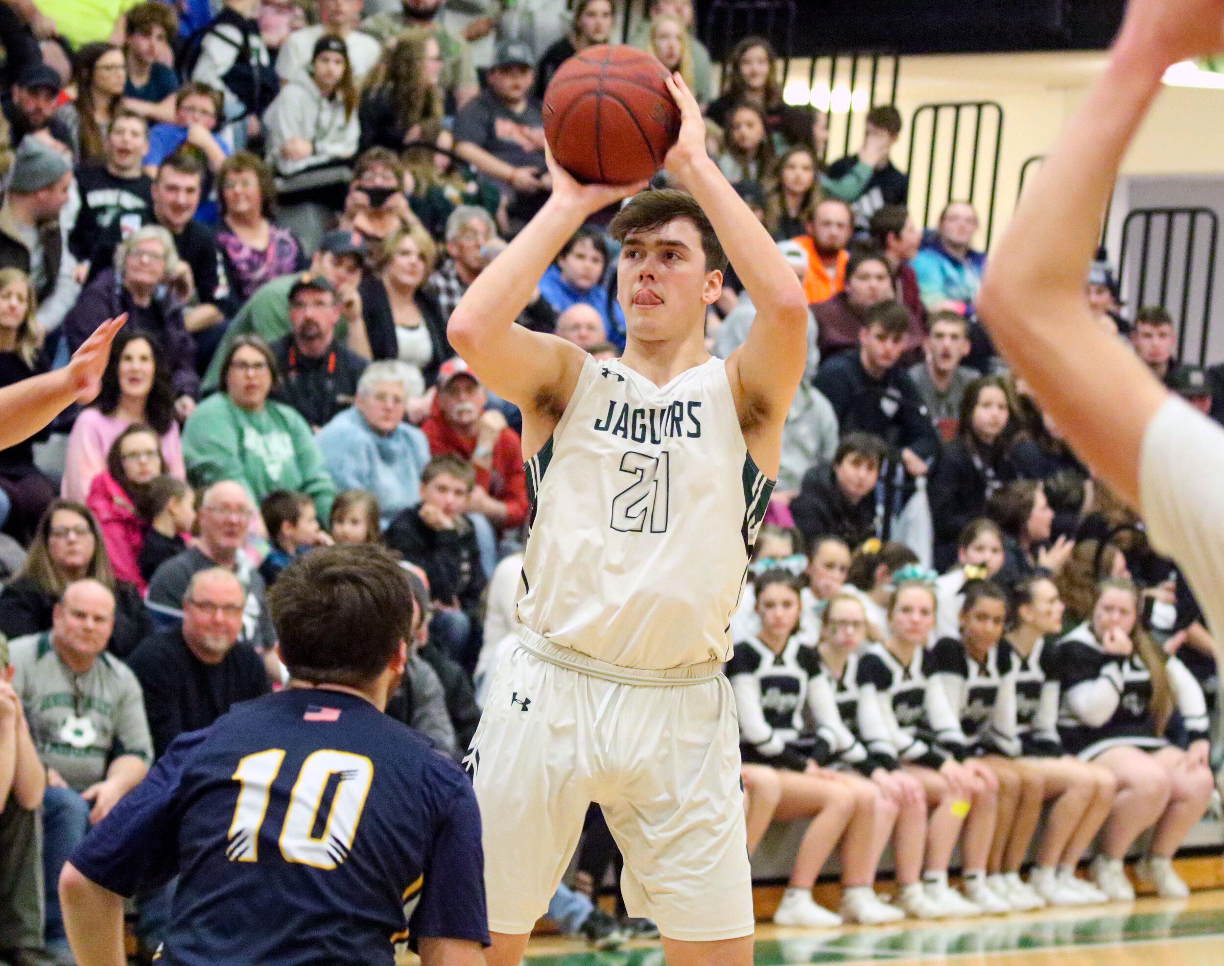  Genesee Valley senior Evan Windus (21) lets a three-point shot fly against the Scio defense of senior Jake D’Arcy (10) during Friday night’s Senior Night contest, in Belmont. [Chris Brooks/WellsvilleSports.com] 