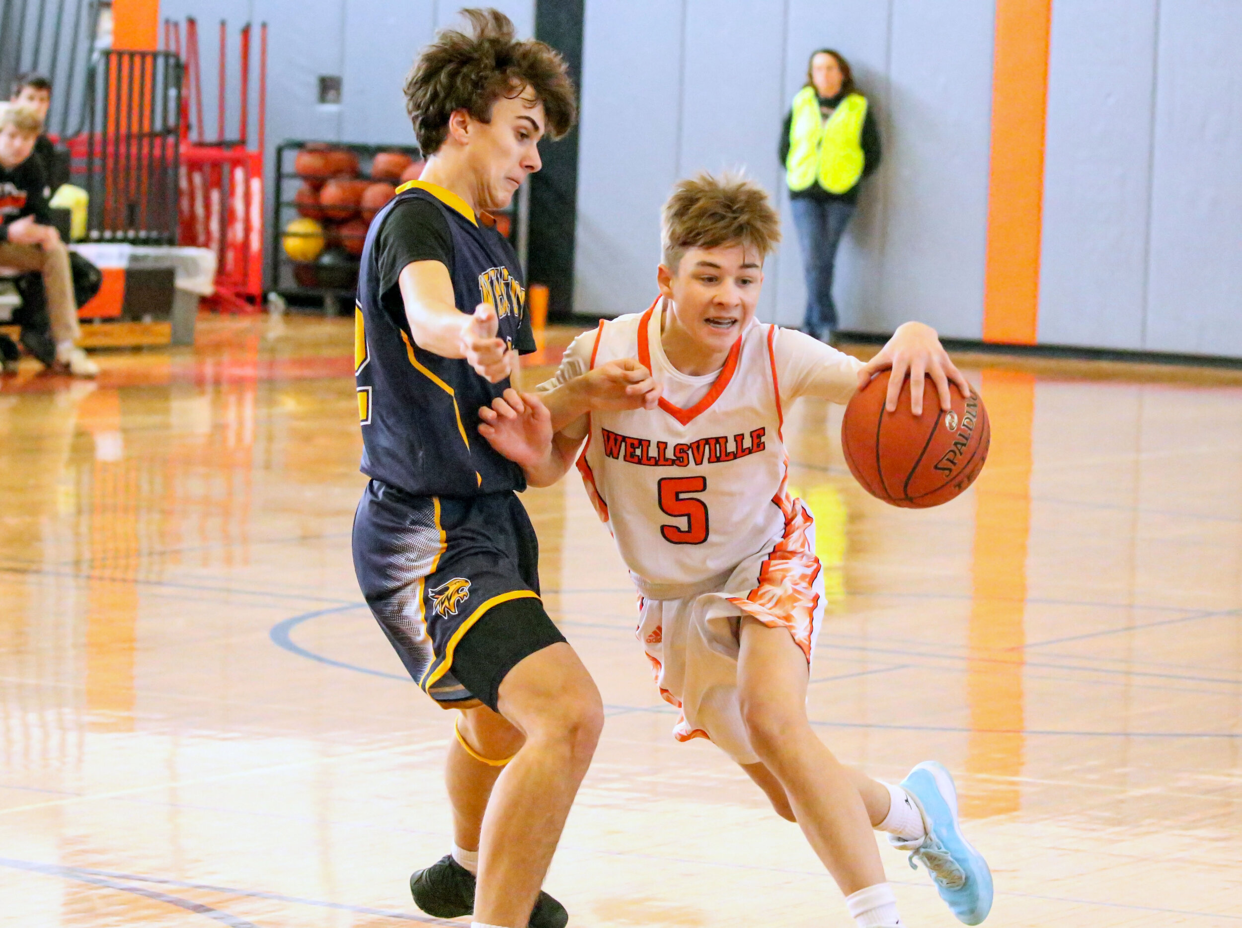  Wellsville sophomore Eli Schmidt (5) drives the lane through the Marcus Whitman defense, on his way inside during Saturday afternoon’s regular season home finale. [Chris Brooks/WellsvilleSports.com] 