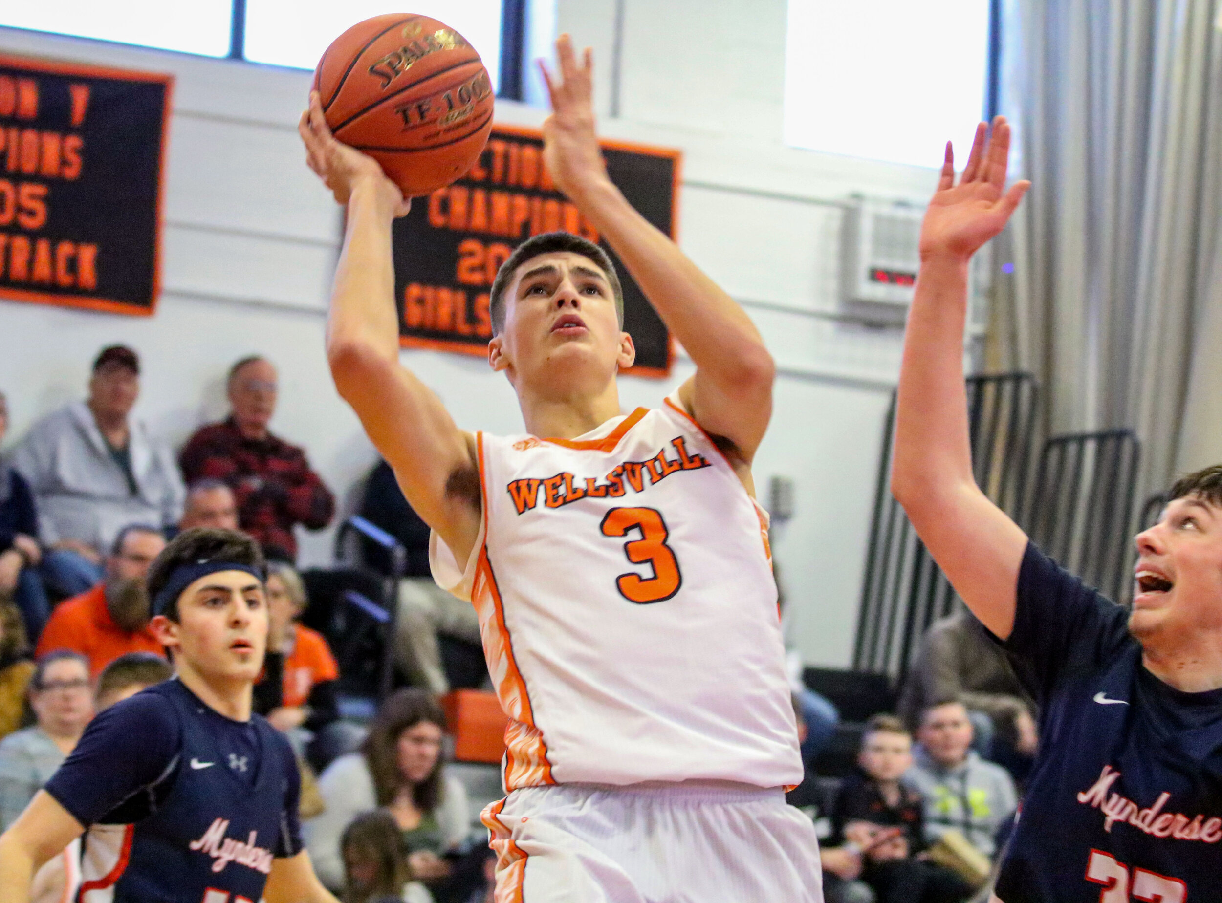  Wellsville senior Max Jusianiec (3) provides an off-balanced runner to the basket, as the Mynderse defense looks to contest the shot during Saturday afternoon’s Class B2 Quarterfinal matchup in Wellsville. [Chris Brooks/WellsvilleSports.com] 